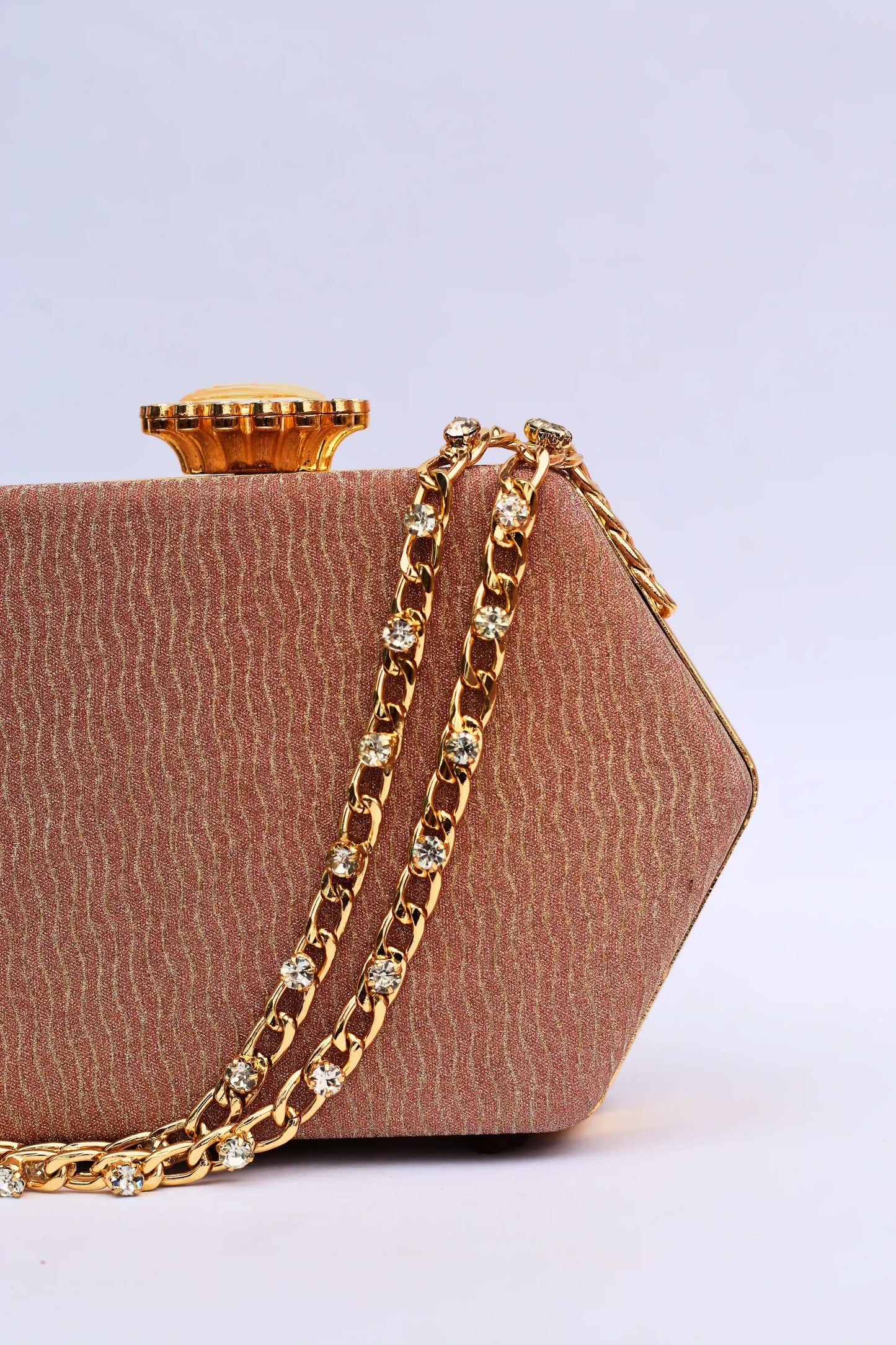 Brown handbag with a gold chain on a light gray background