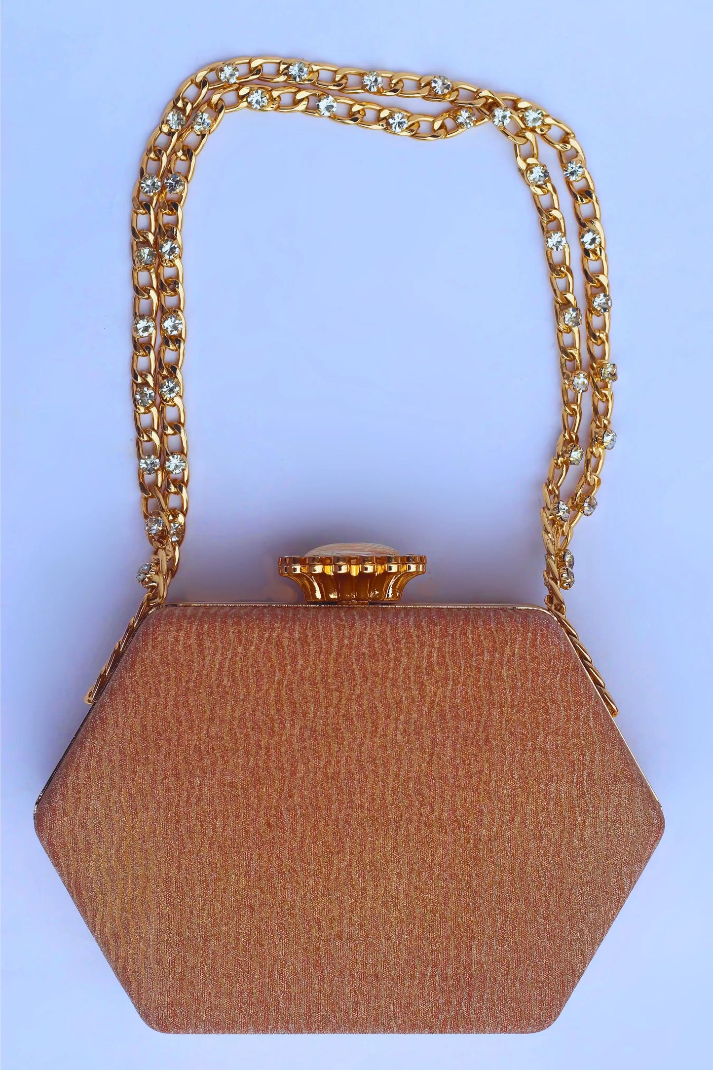 Golden Brown bride clutch bag with gold chain handle on a light blue background