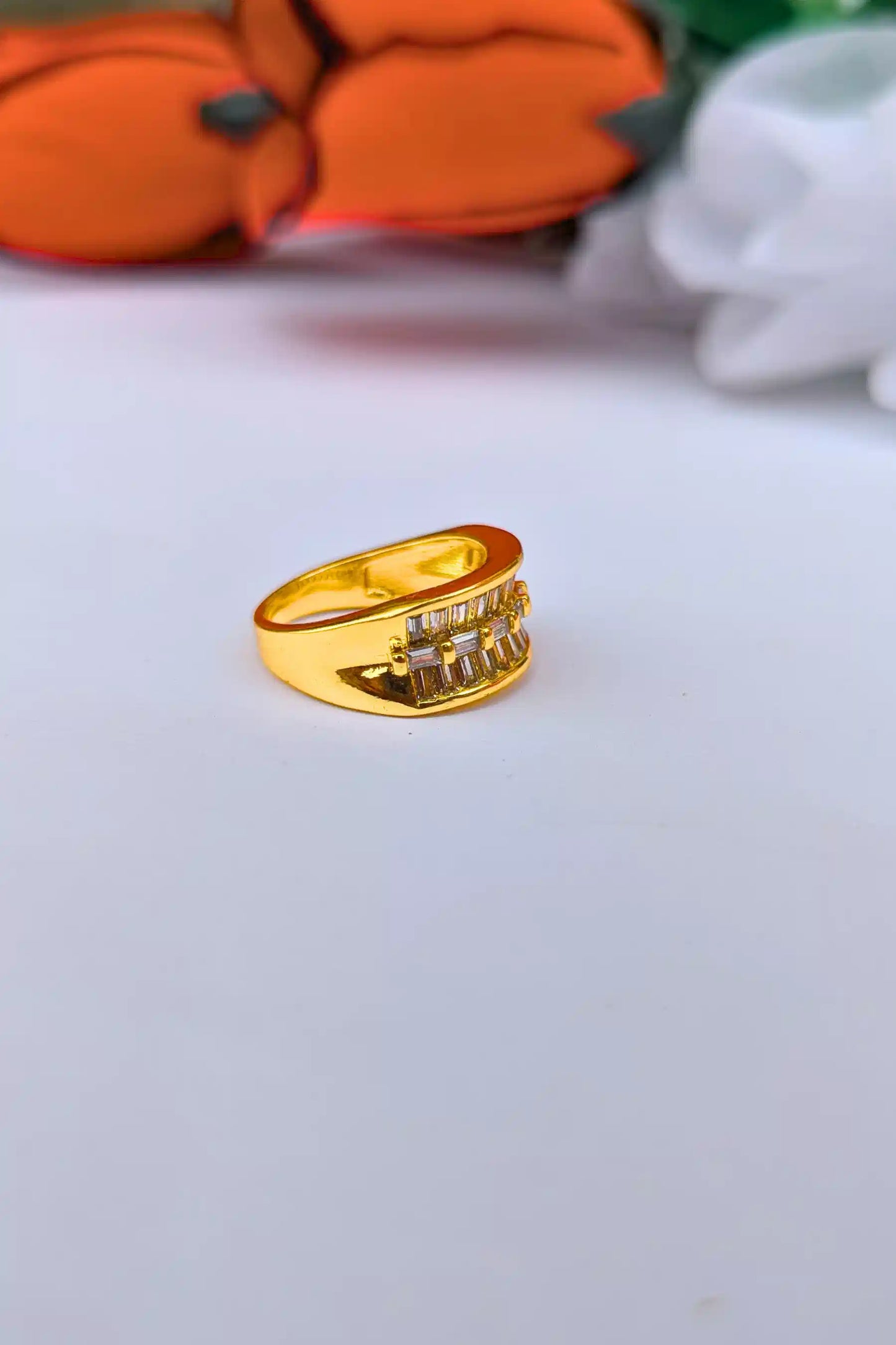 Gold ring with a white stone on a light gray background