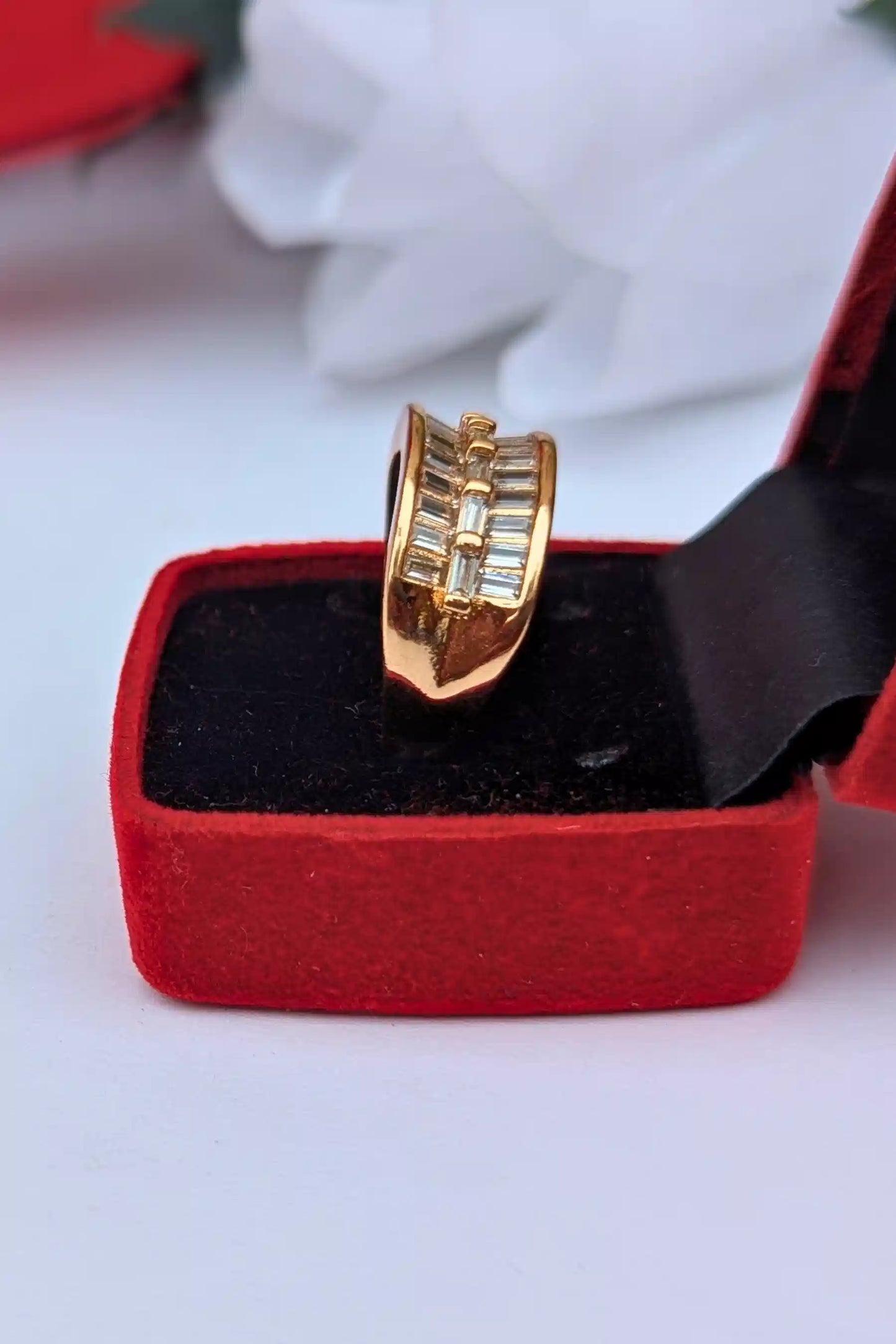 Gold ring in a red box on a white background