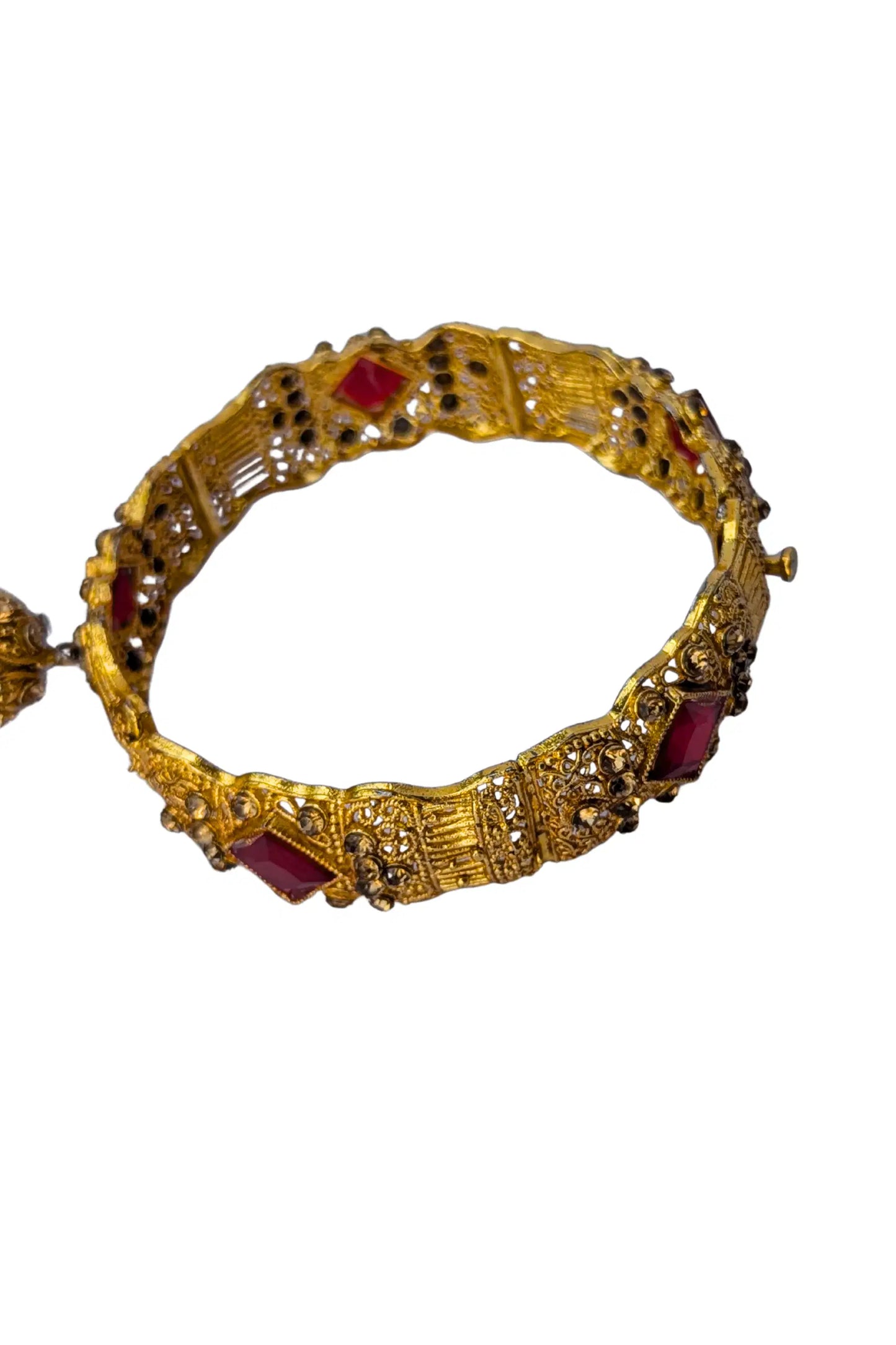 Gold bracelet with red gemstones on a white background
