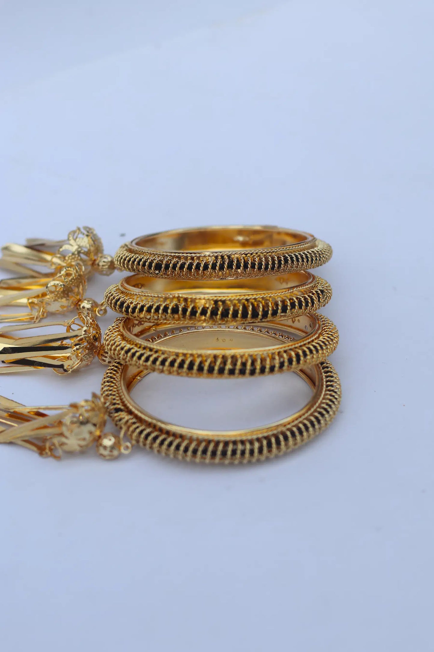 Set of gold bangles on a light blue background