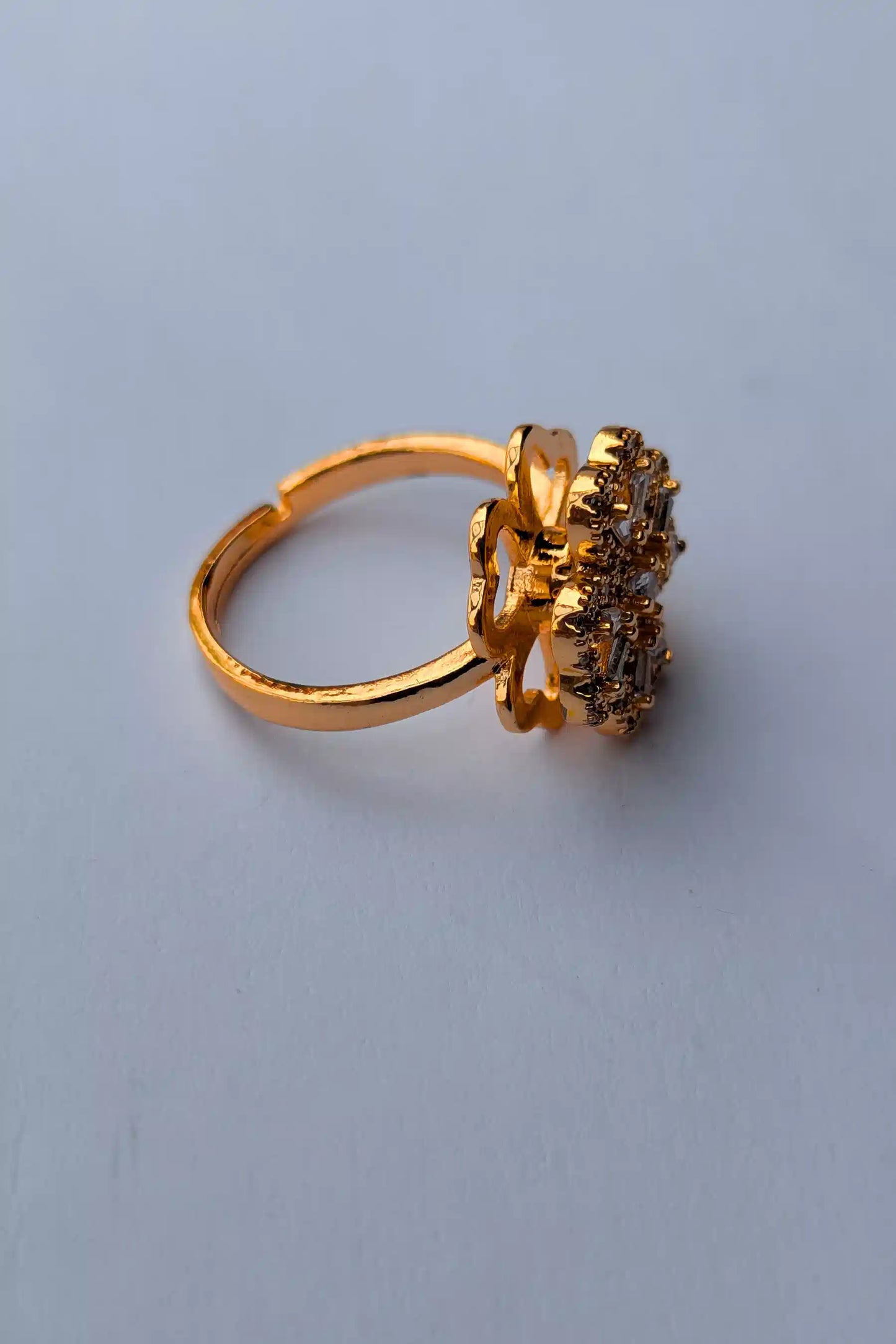 Gold ring with a cluster of gemstones on a light gray background