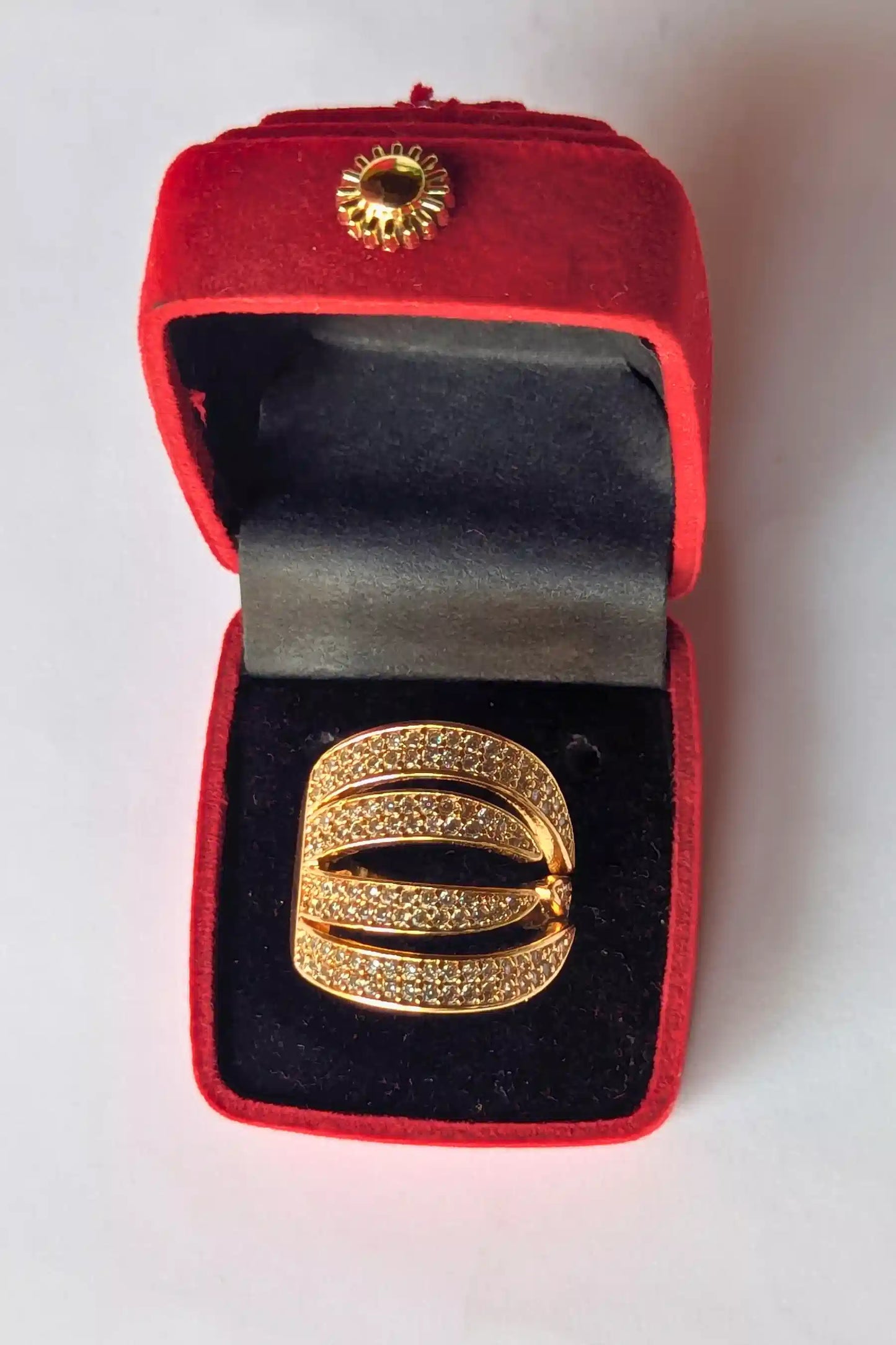 Gold ring in a red velvet box on a white background
