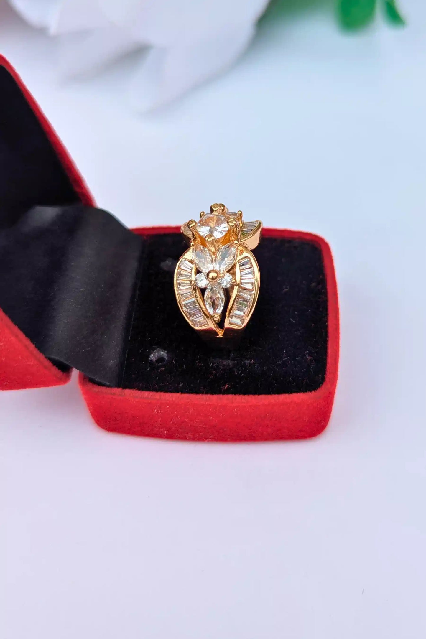 Gold ring with pearls on a red and black jewelry box