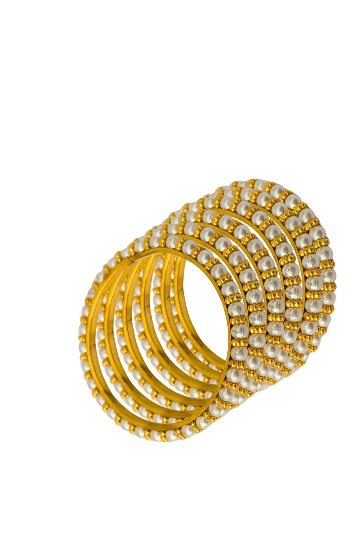 Set of gold and pearl bangles on a white background