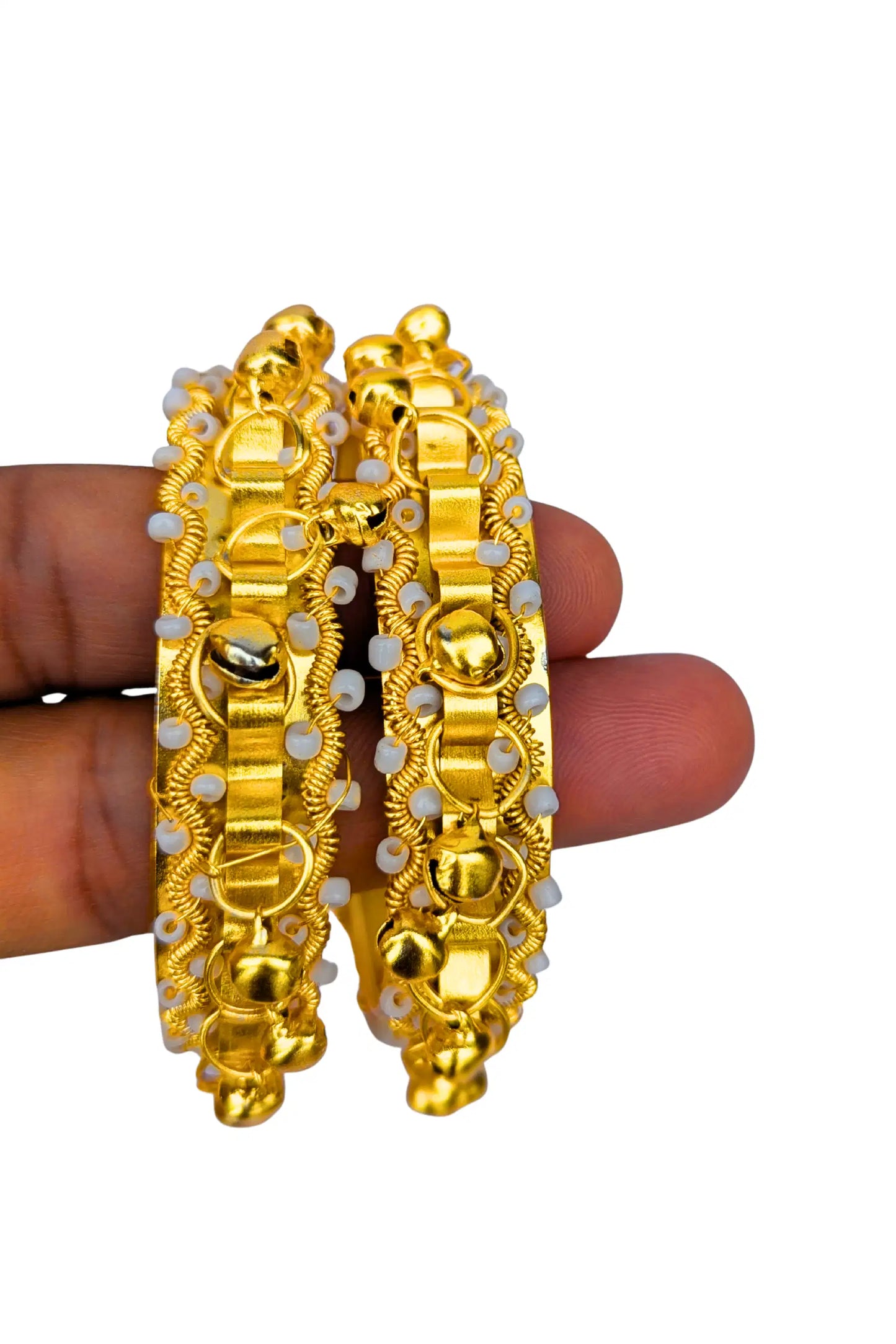 Gold bangles with white stones held by a hand on a white background