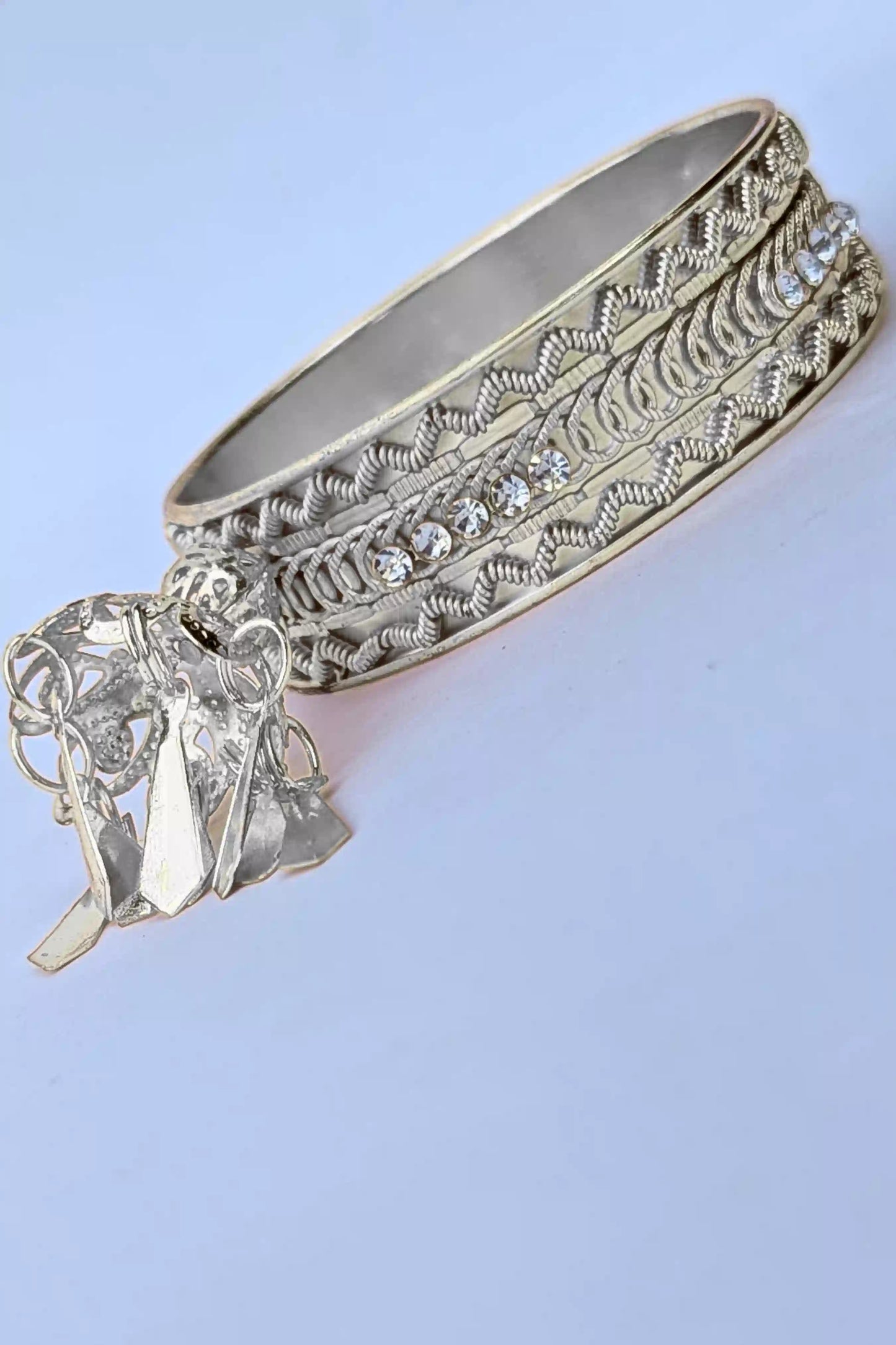 Silver bracelet with intricate designs on a light blue background