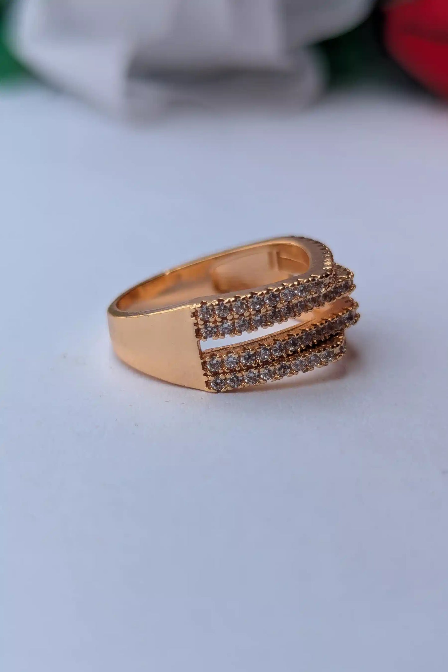 Rose gold ring with brown gemstones on a light gray background