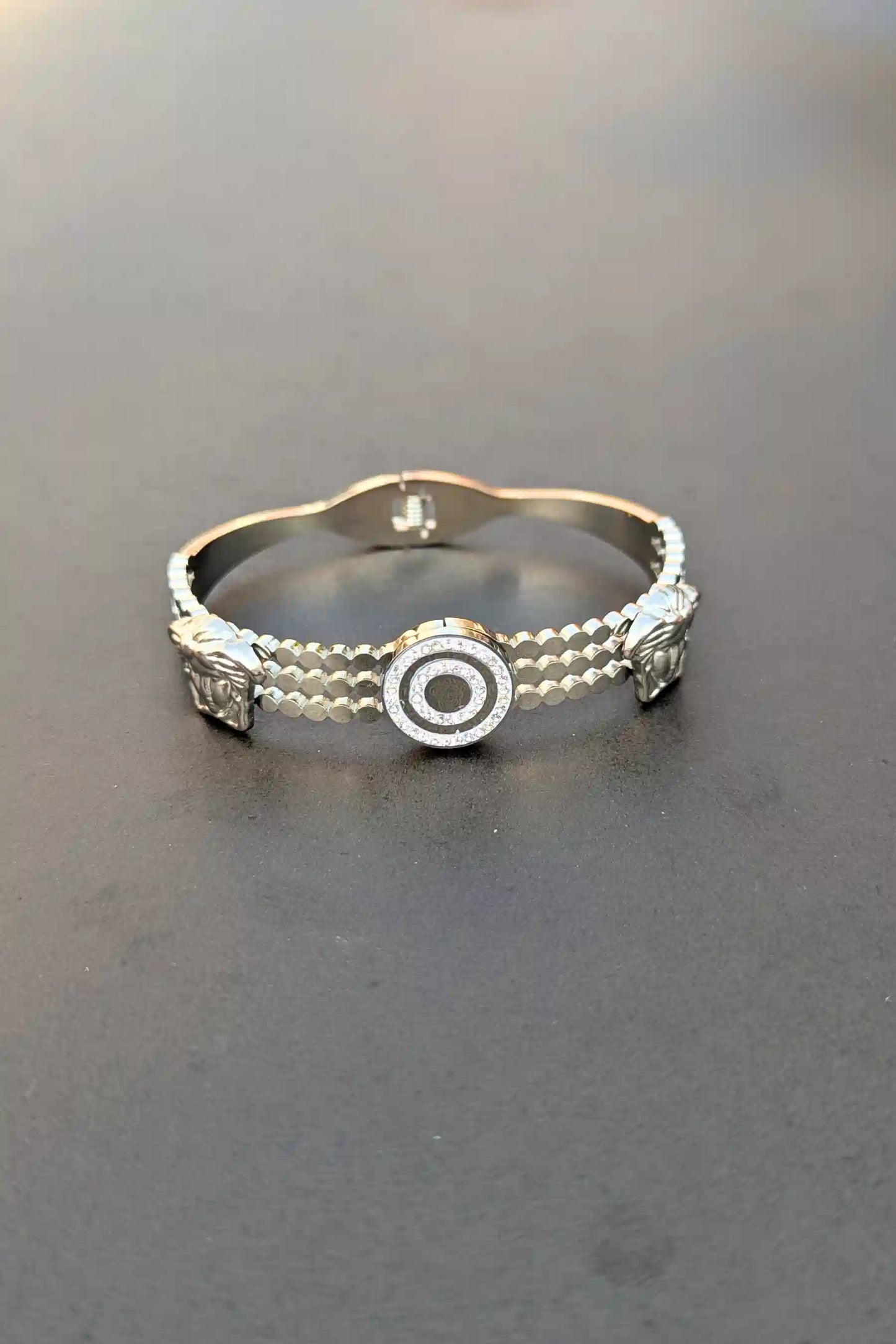 Silver bracelet with decorative elements on a dark surface