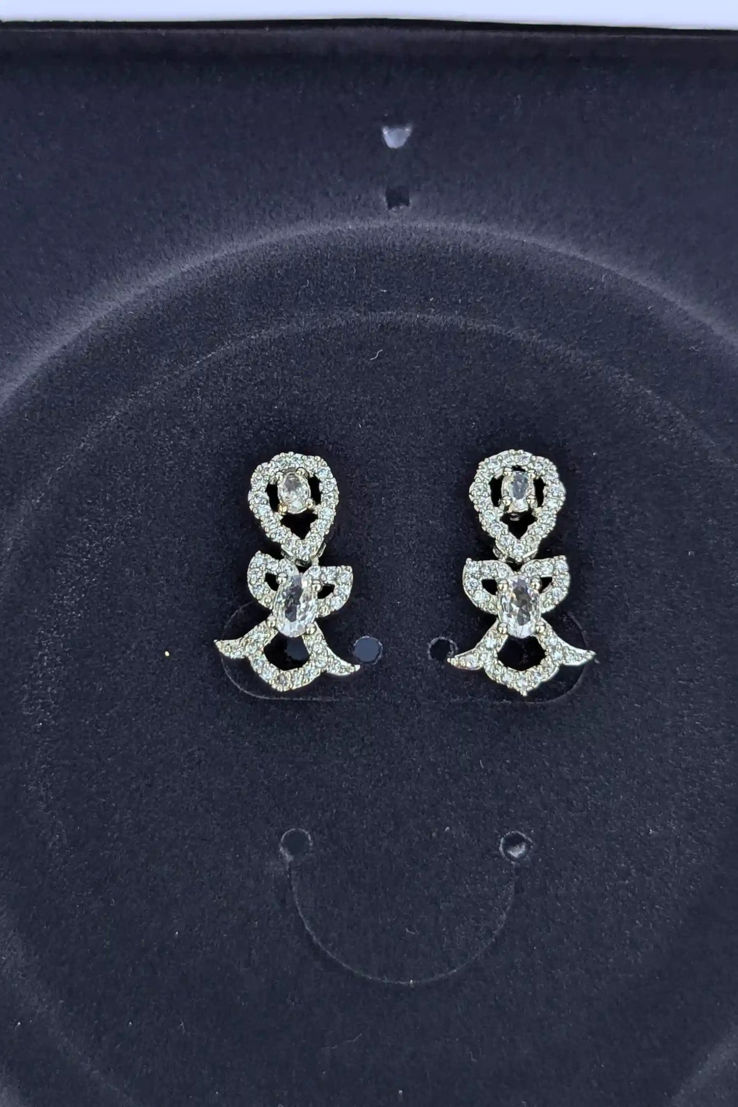 Pair of silver flower-shaped earrings on a dark background
