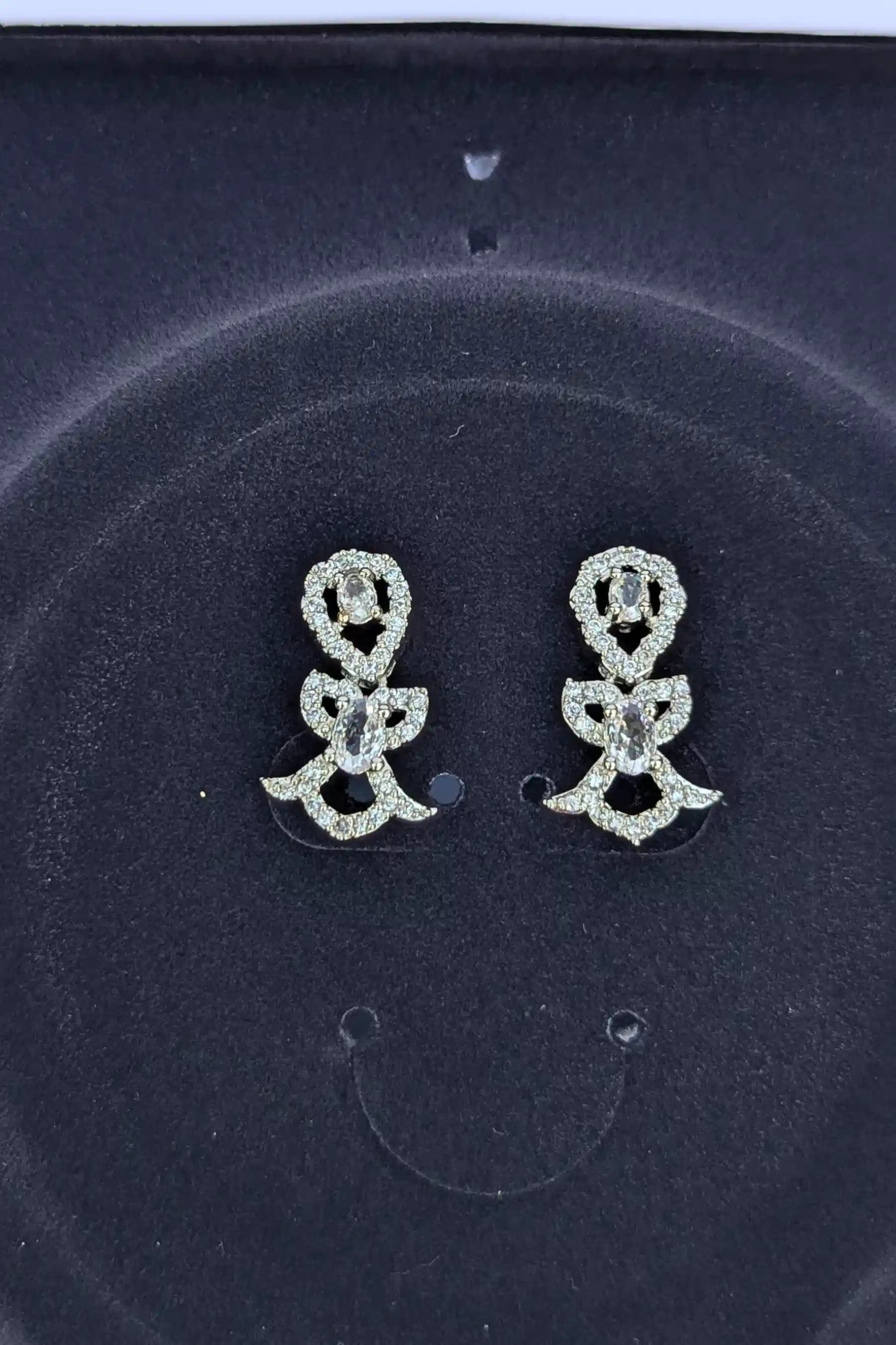 Pair of silver flower-shaped earrings on a dark background