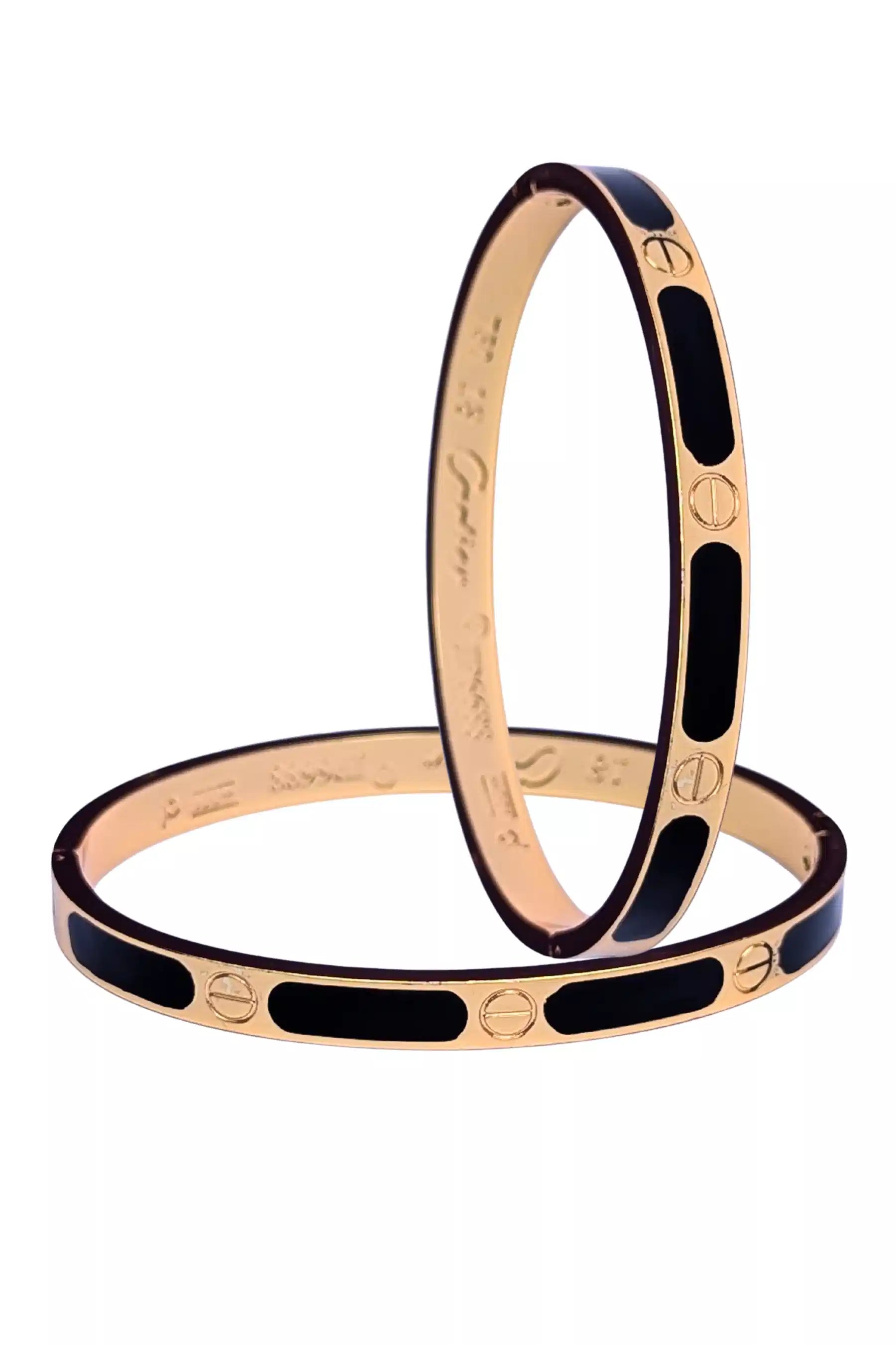 Two rose gold bangles with black enamel accents on a white background