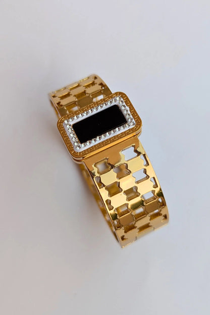 Gold watch with a black face on a light gray background