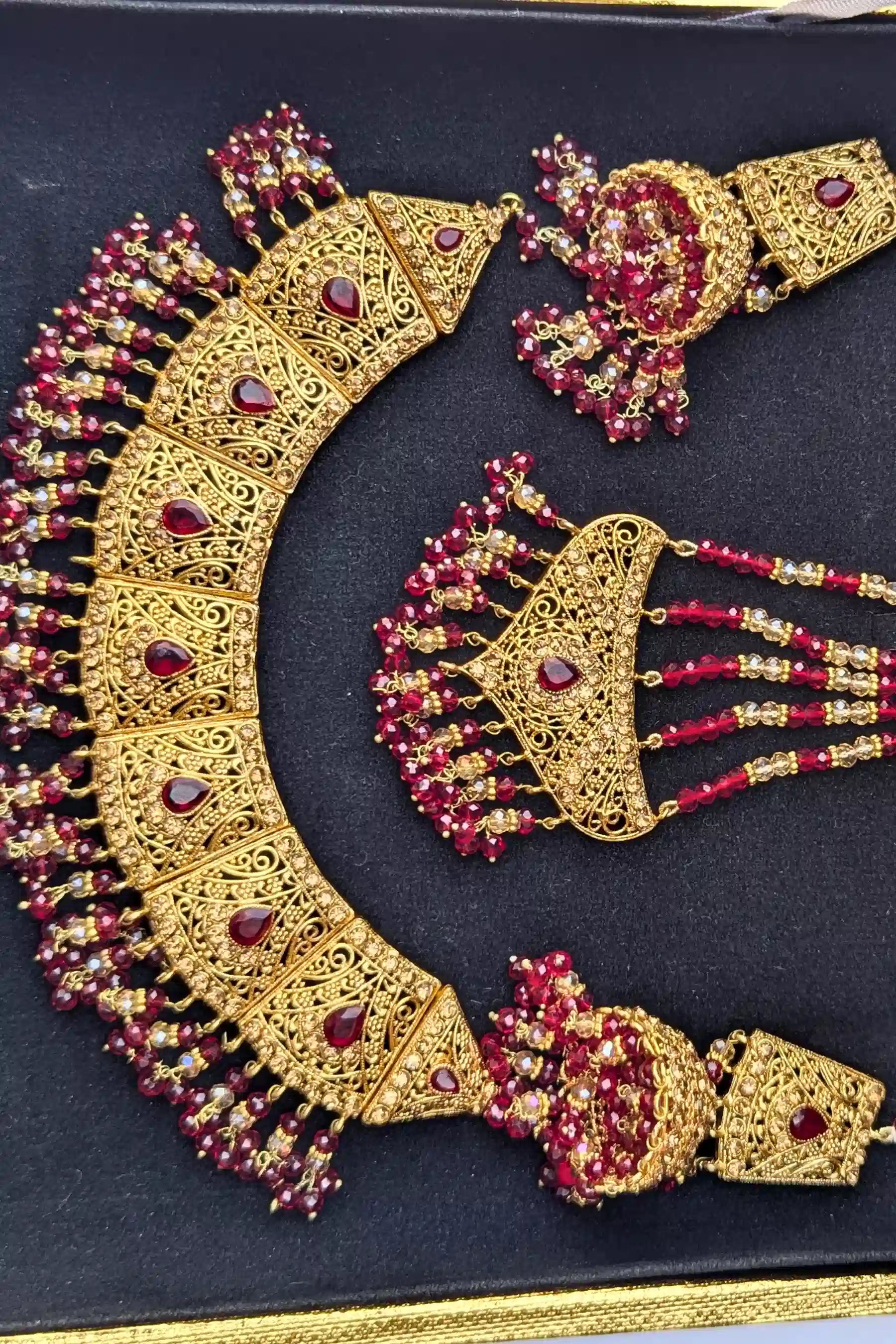 Gold and red jewelry set on a black background