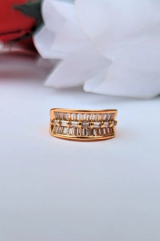 Gold ring with diamond accents on a white surface