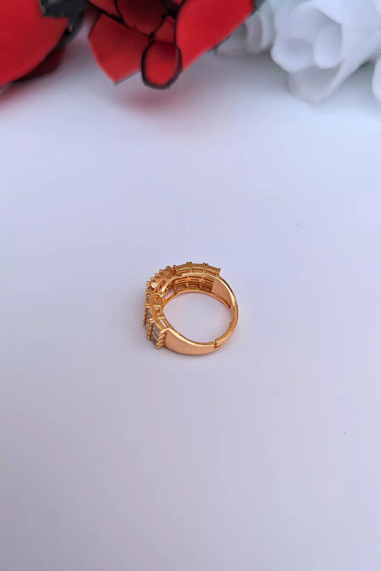 Gold ring with gemstones on a light gray background