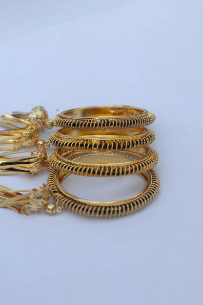 Set of gold bangles on a light blue background