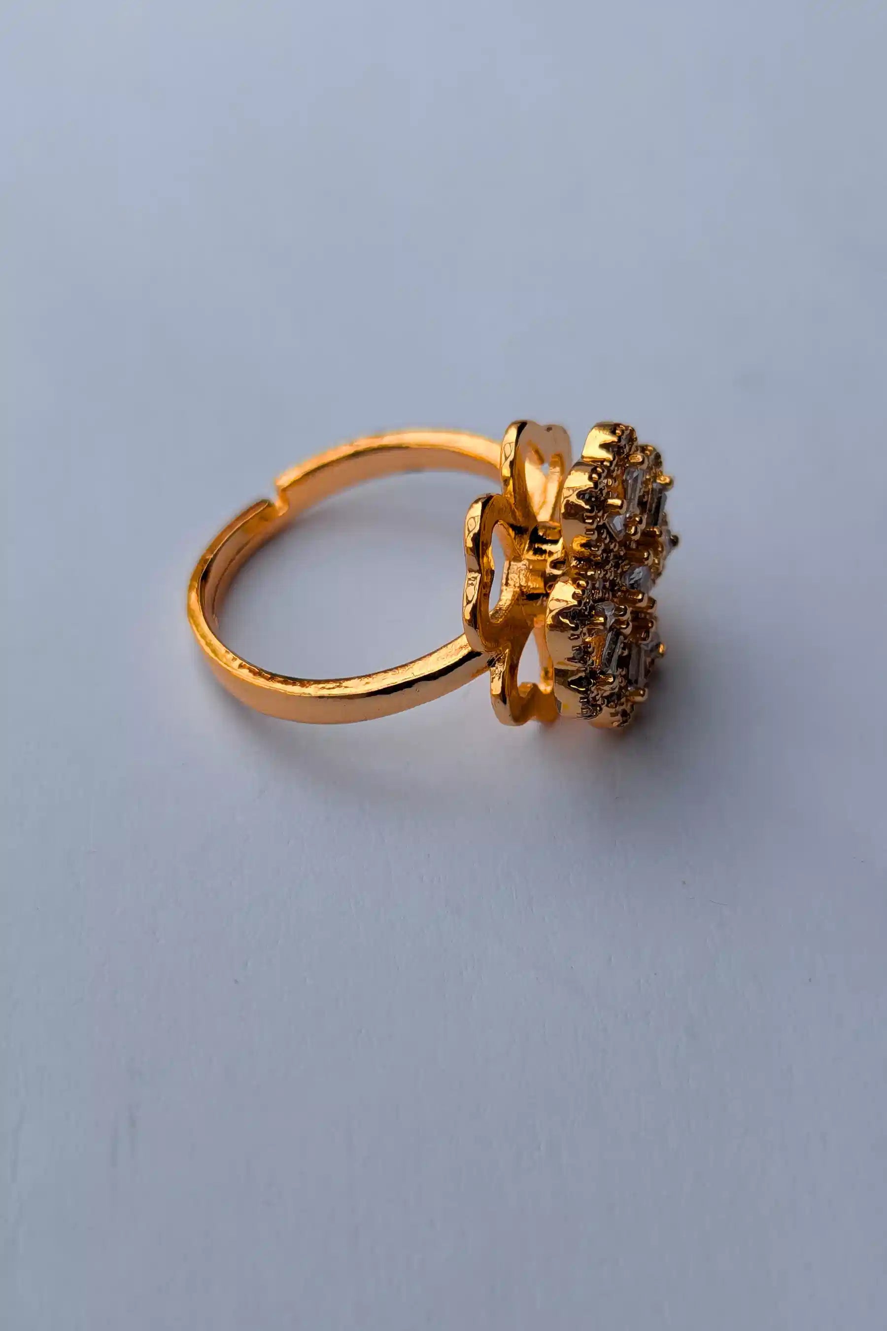 Gold ring with a cluster of gemstones on a light gray background