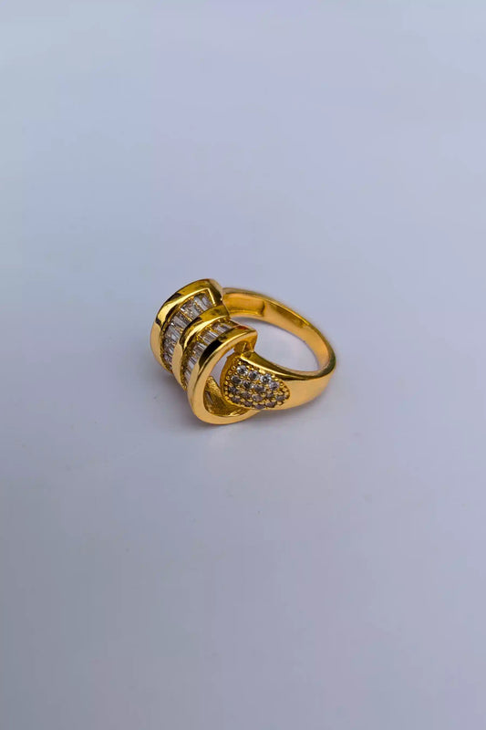 Gold ring with embedded stones on a light gray background