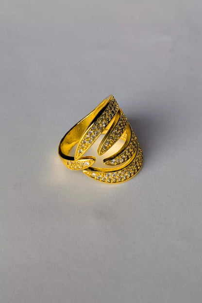 Gold ring with intricate design on a gray background
