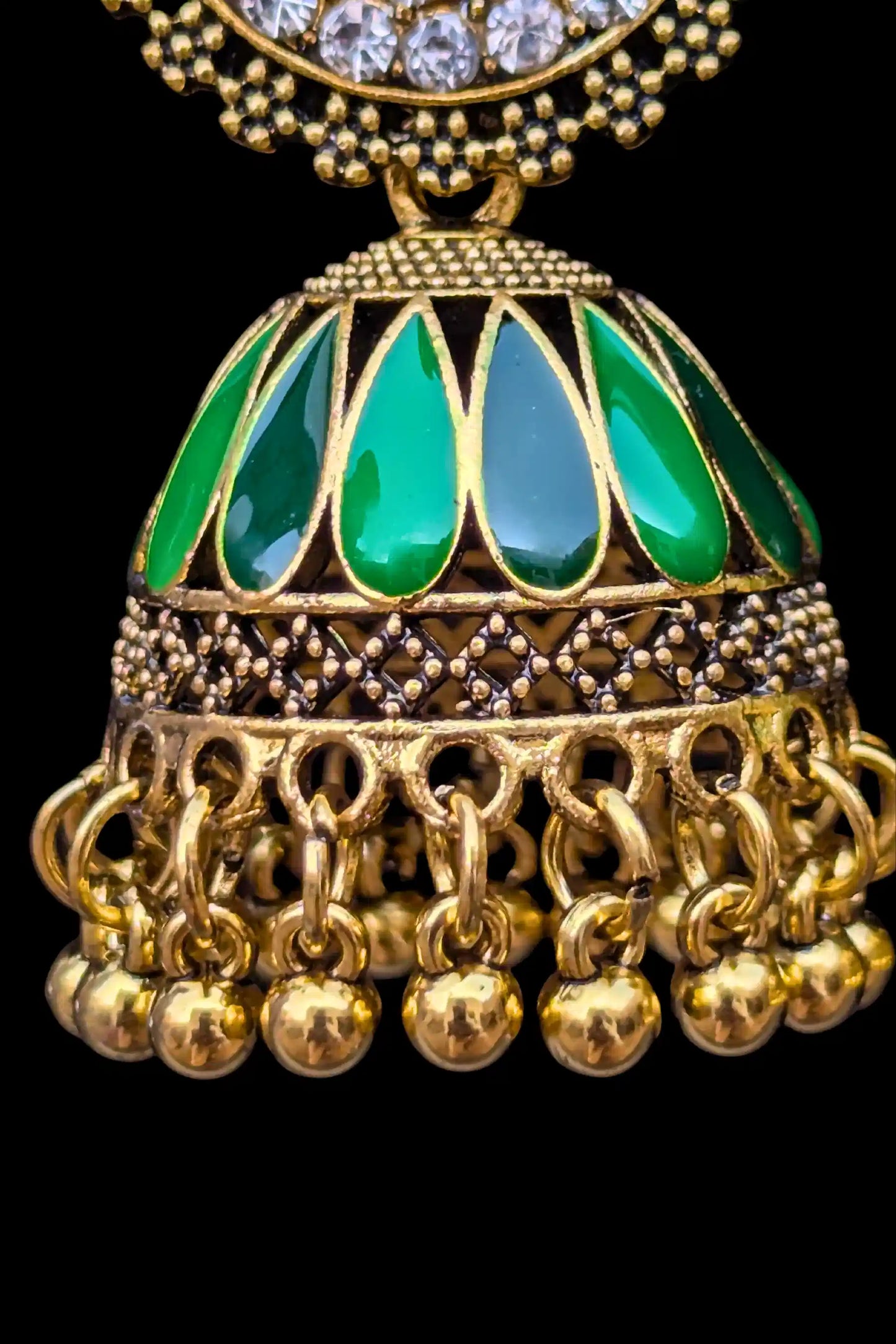 Gold and green decorative pendant on a black background