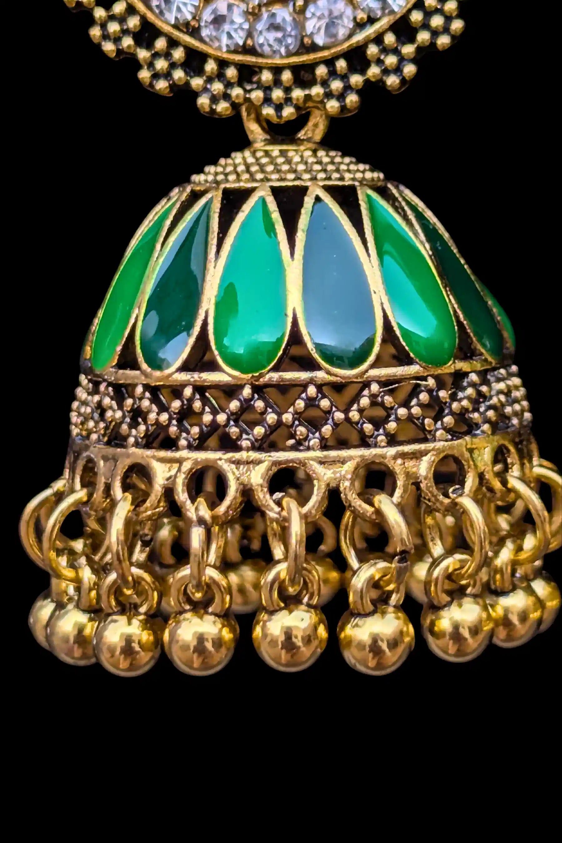 Gold and green decorative pendant on a black background