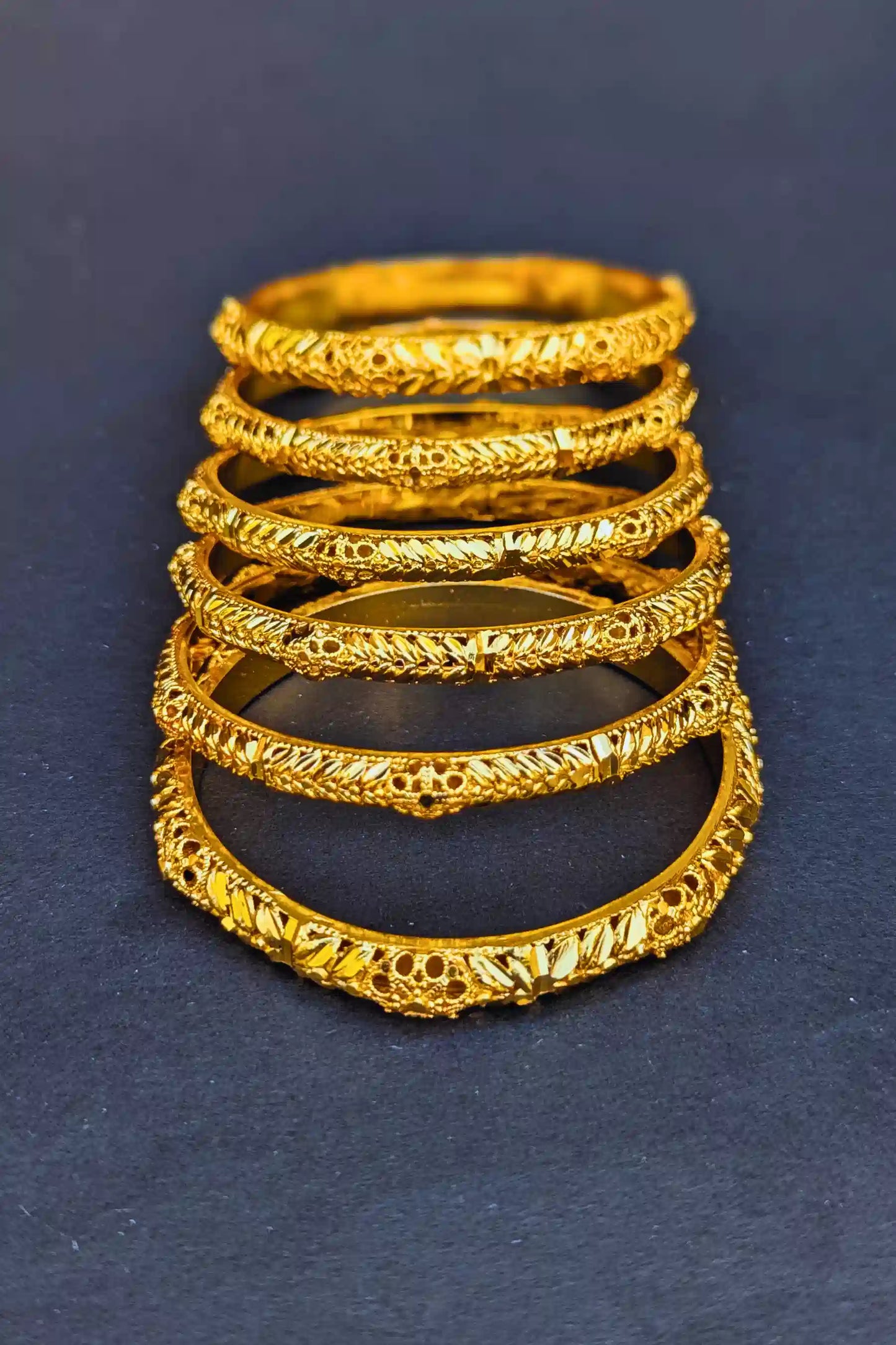 Set of gold rings stacked on a dark blue background