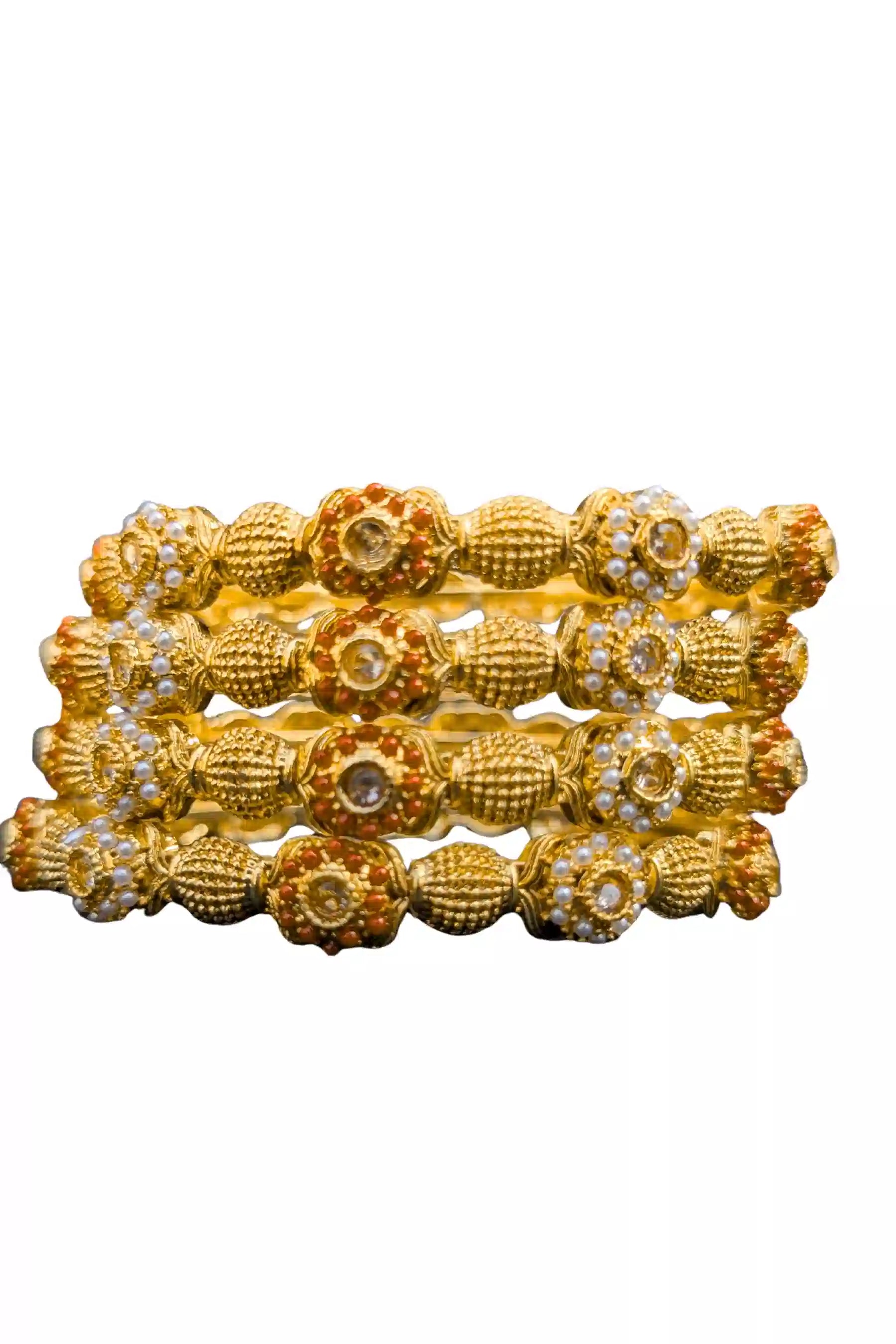 Set of gold bangles with intricate designs on a white background
