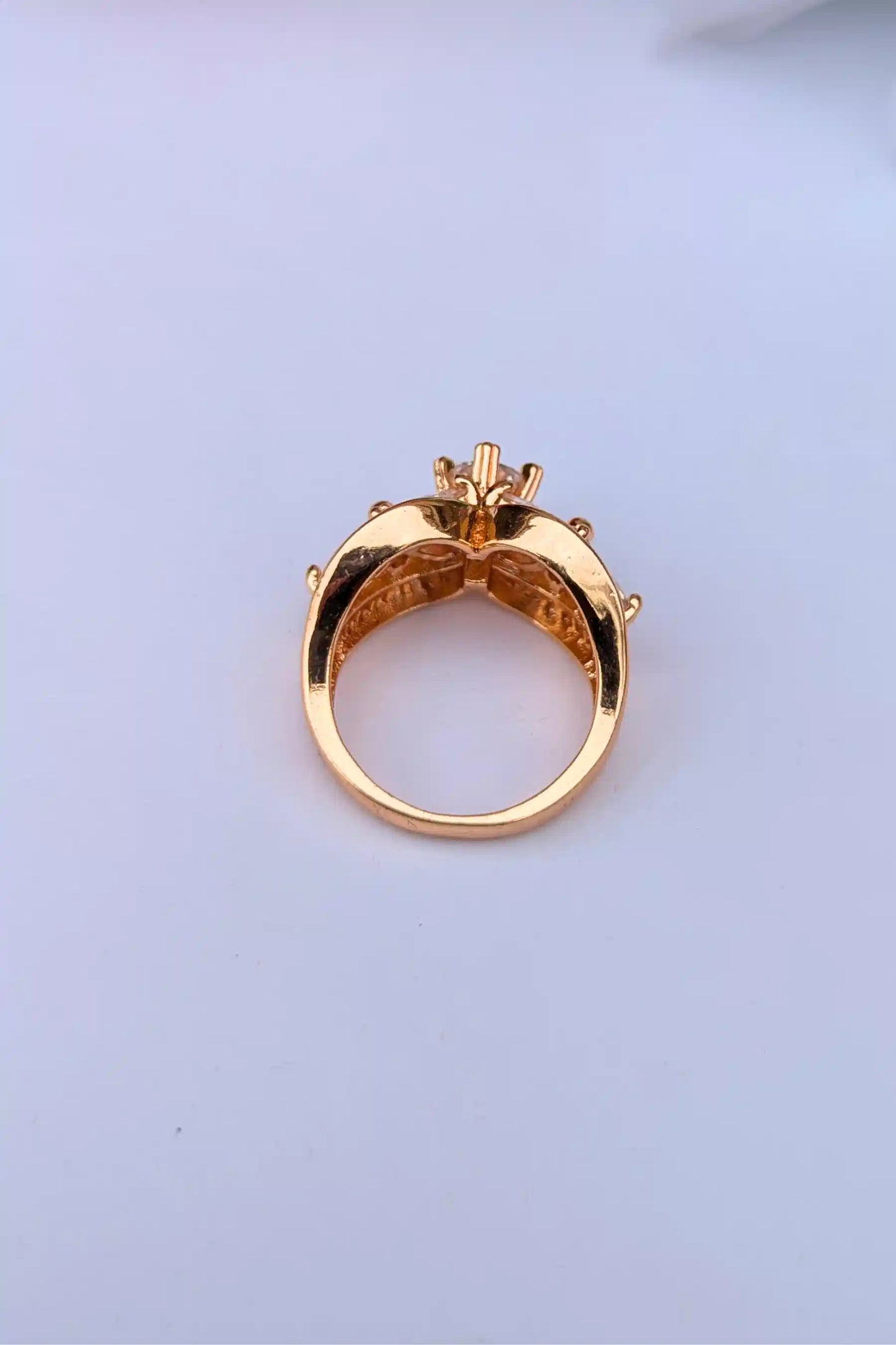 Gold ring with a diamond on a light blue background