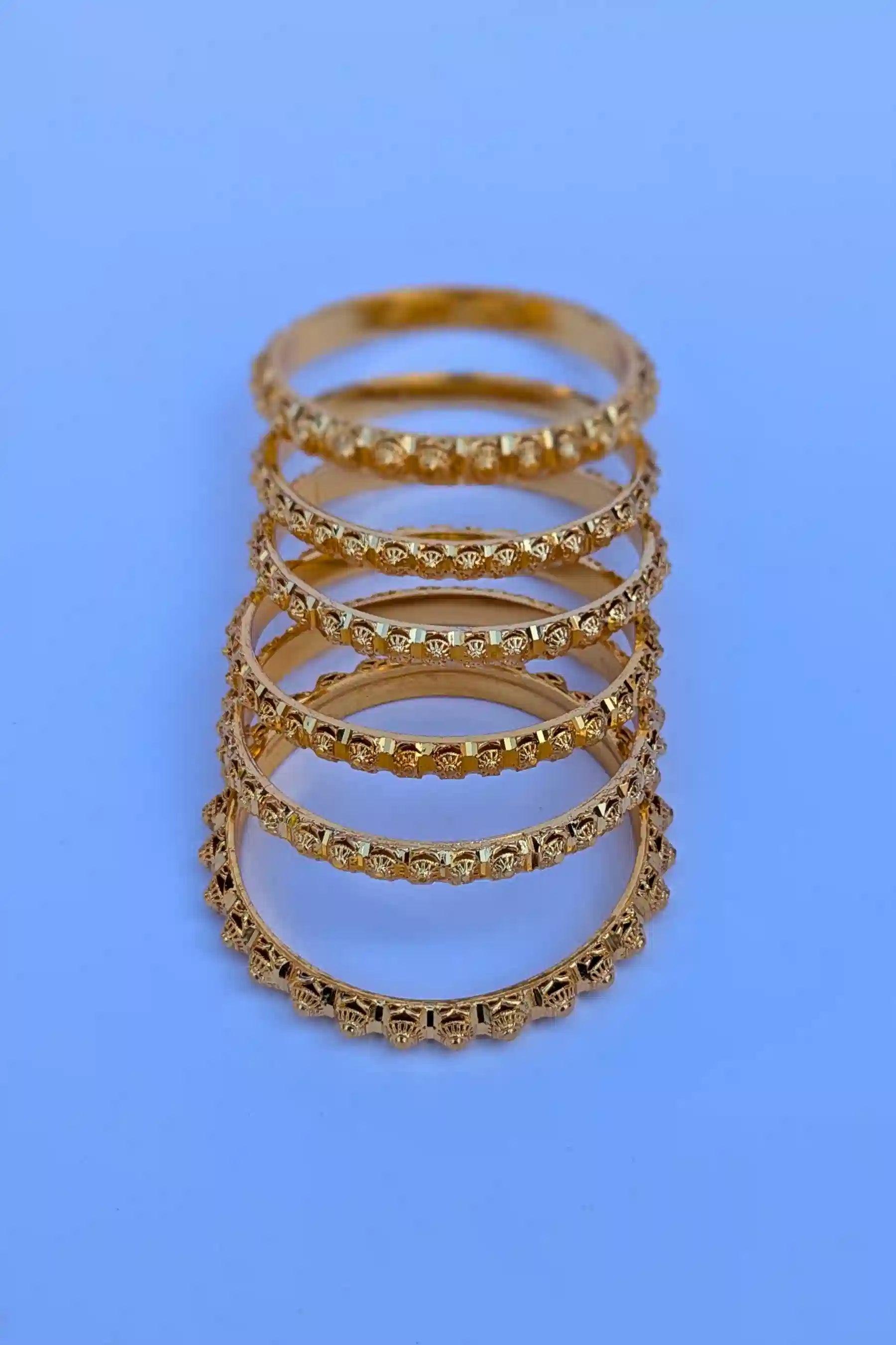 Set of gold rings stacked on a blue background