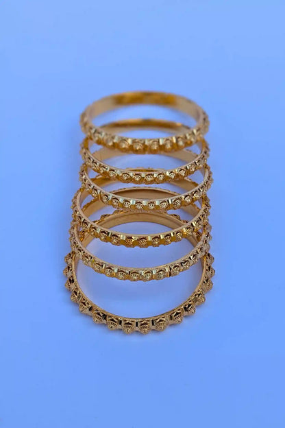 Set of gold rings stacked on a blue background