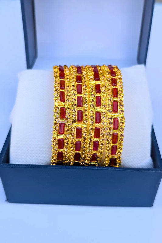 Gold and red bracelet on a white cushion with a blue box background
