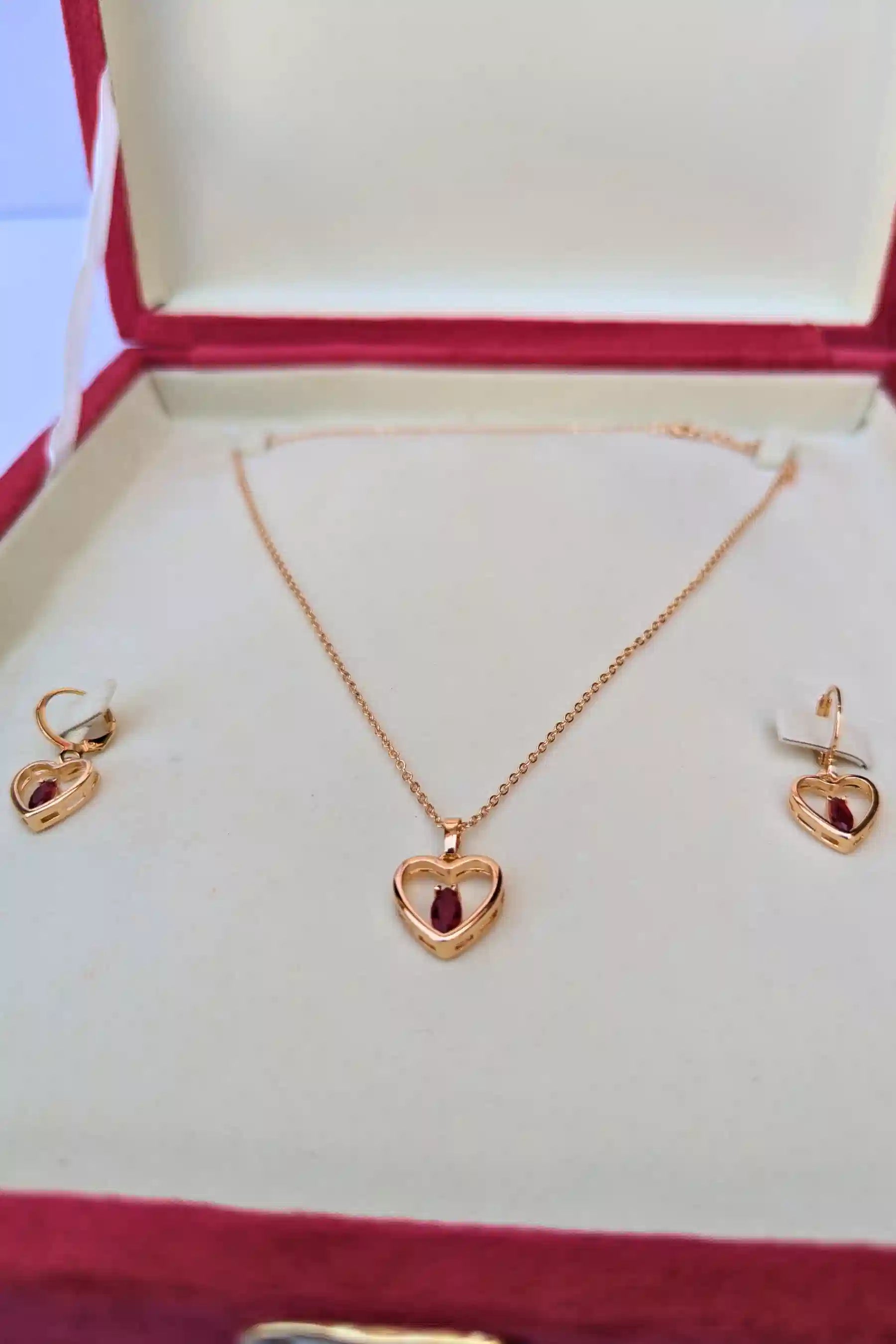 Gold heart-shaped necklace and earrings set in a jewelry box