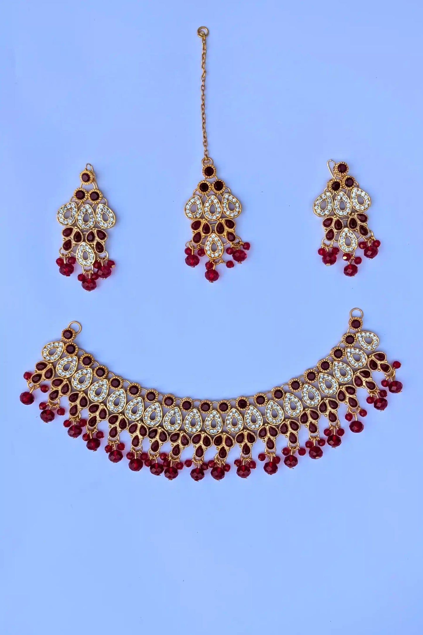 Necklace set with matching earrings on a blue background