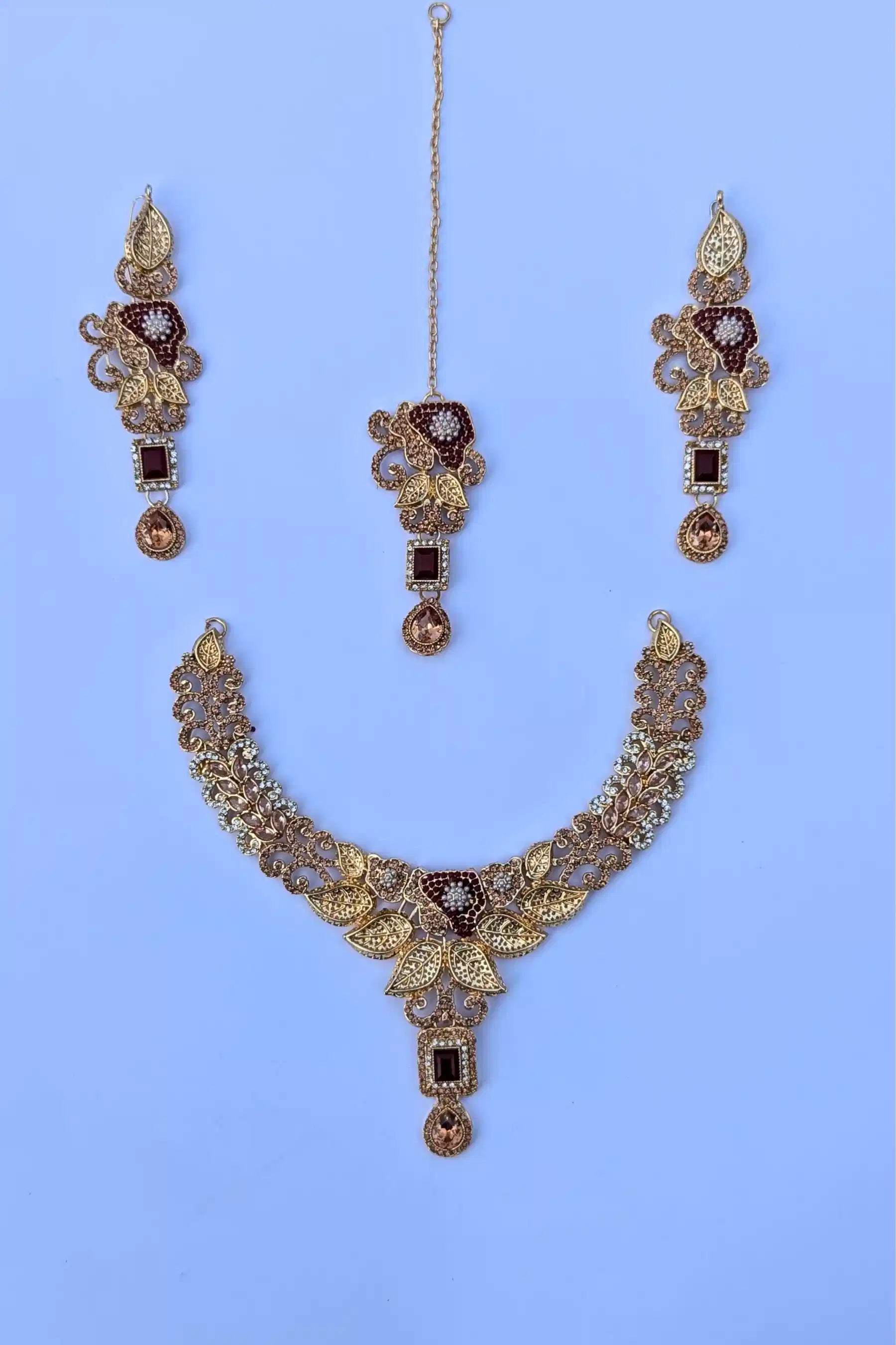 Jewelry set with necklace, earrings, and ring on a light blue background