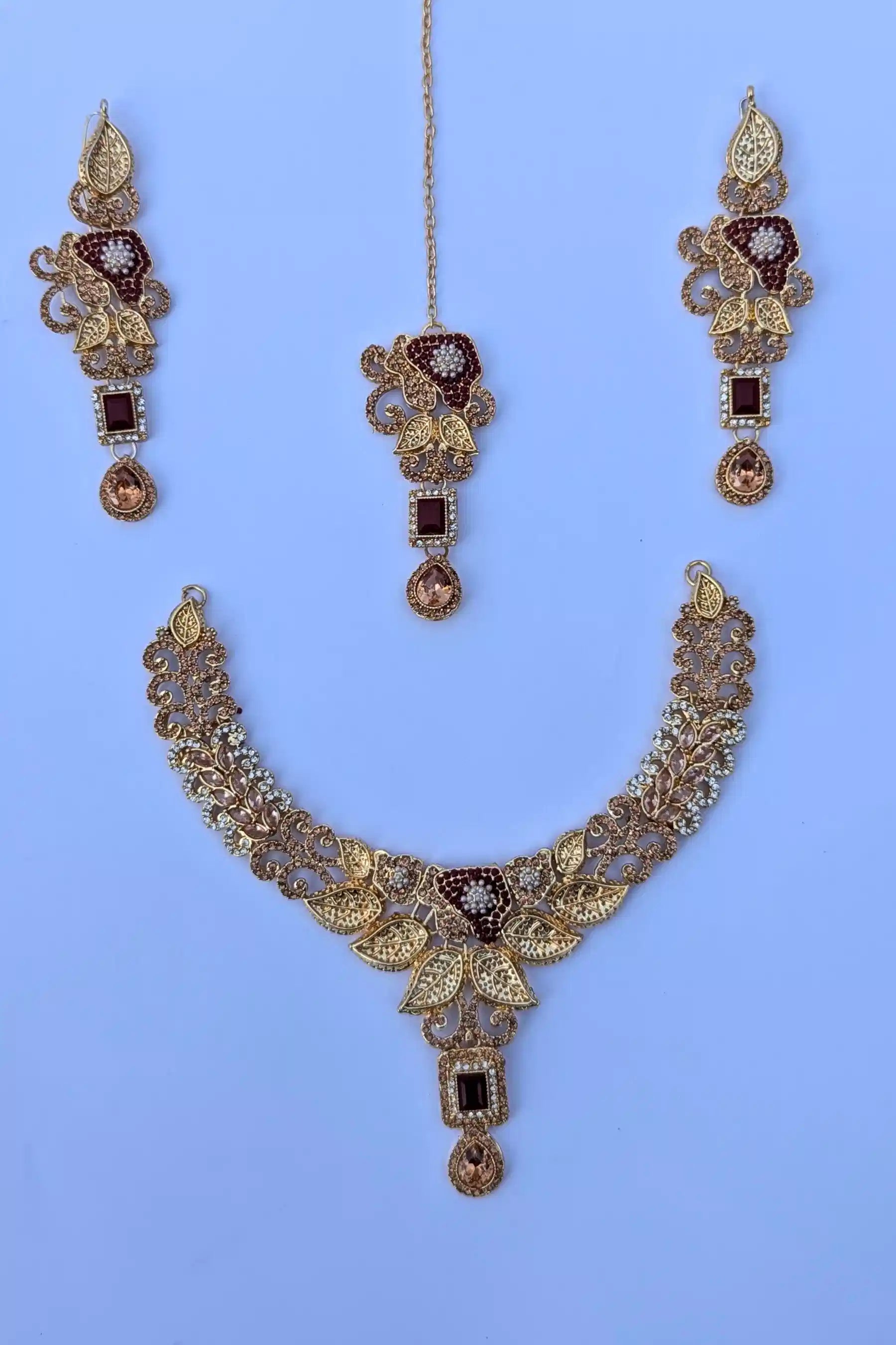Gold necklace with matching earrings on a blue background