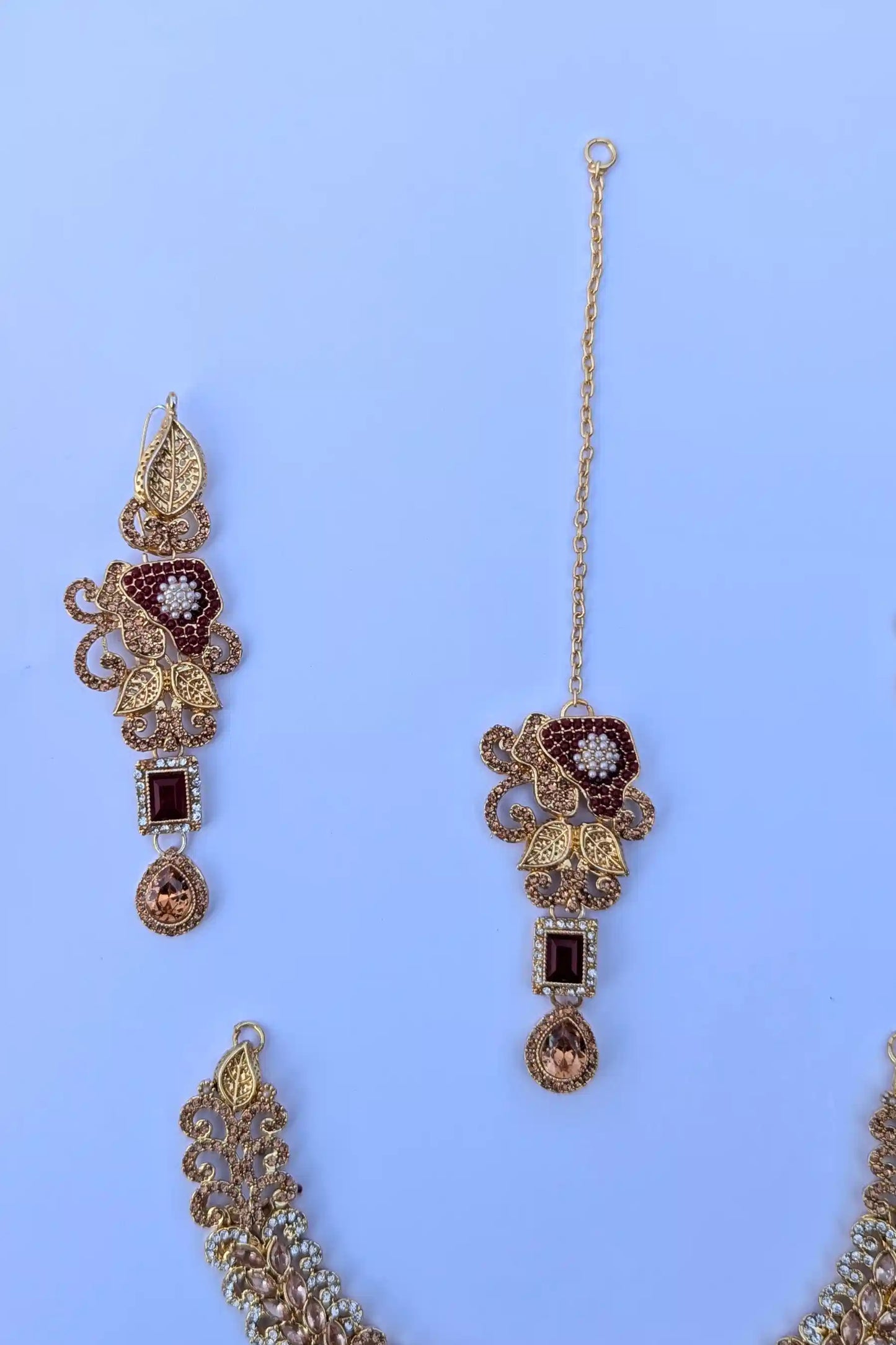 Decorative earrings with gold and brown accents on a blue background