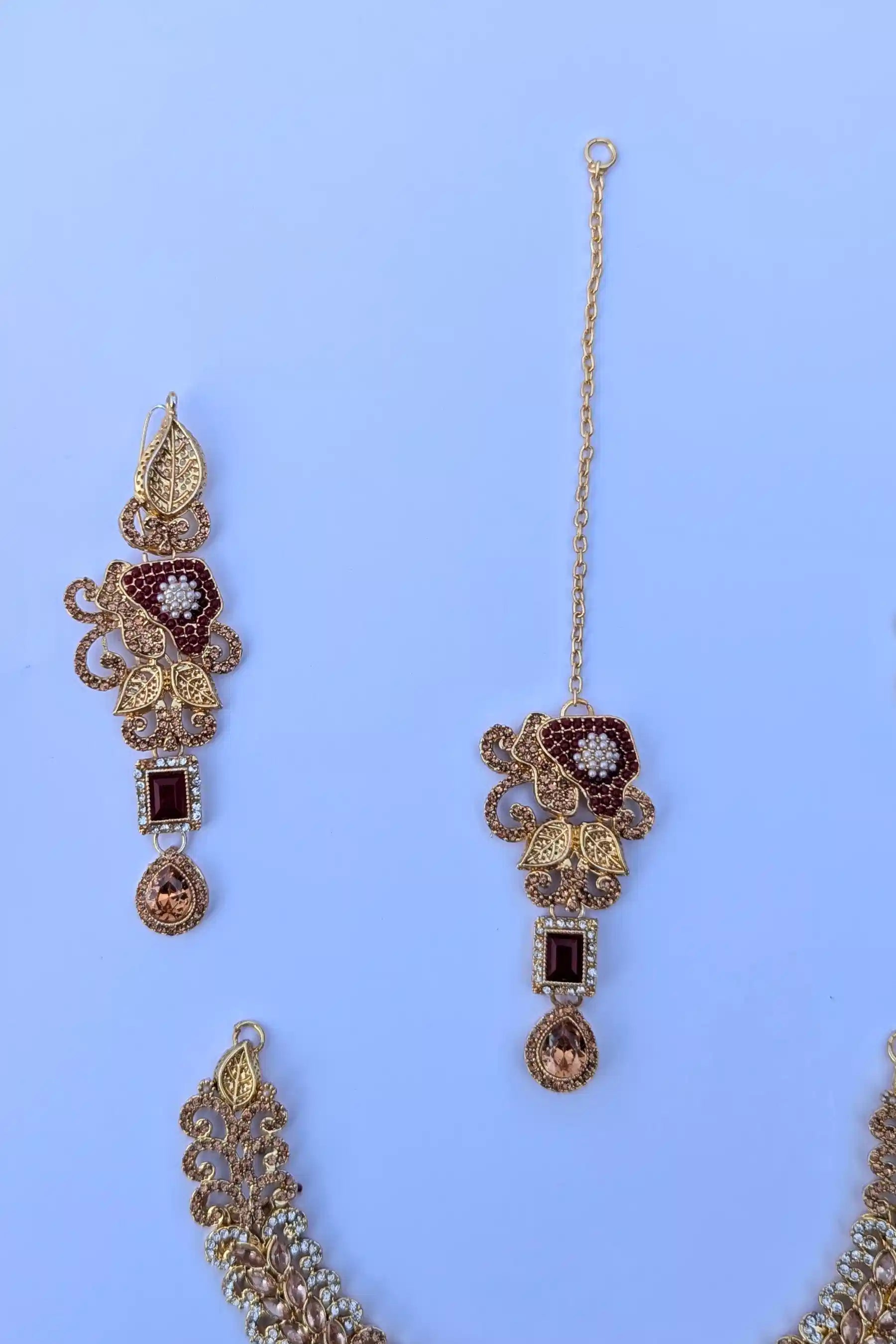 Decorative earrings with gold and brown accents on a blue background