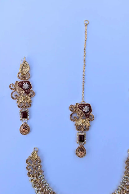 Decorative earrings with gold and brown accents on a blue background