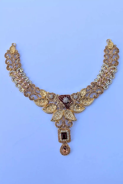 Gold necklace with intricate design on a light blue background