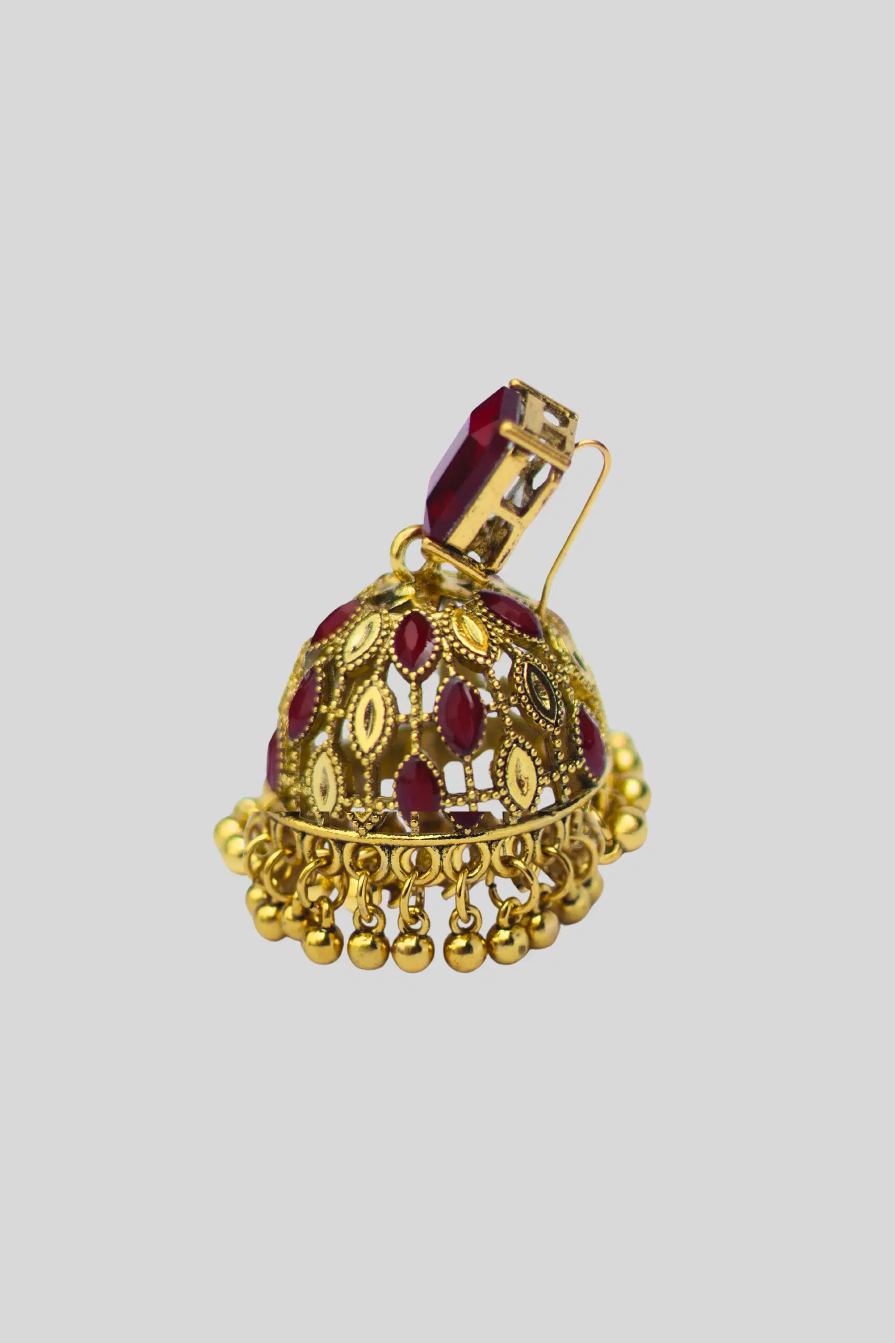Gold and red gemstone pendant on a light gray background