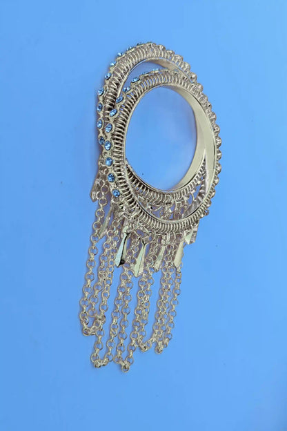 Decorative silver brooch with chains on a blue background