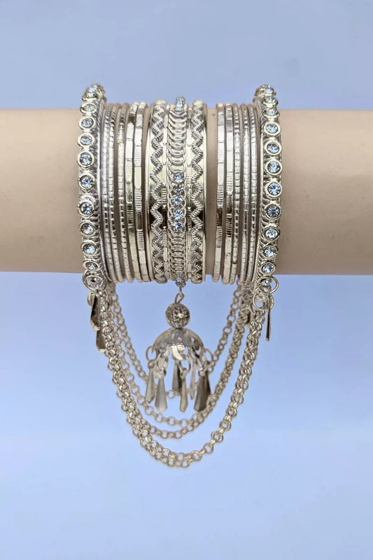 Stack of silver bracelets with intricate designs on a light blue background