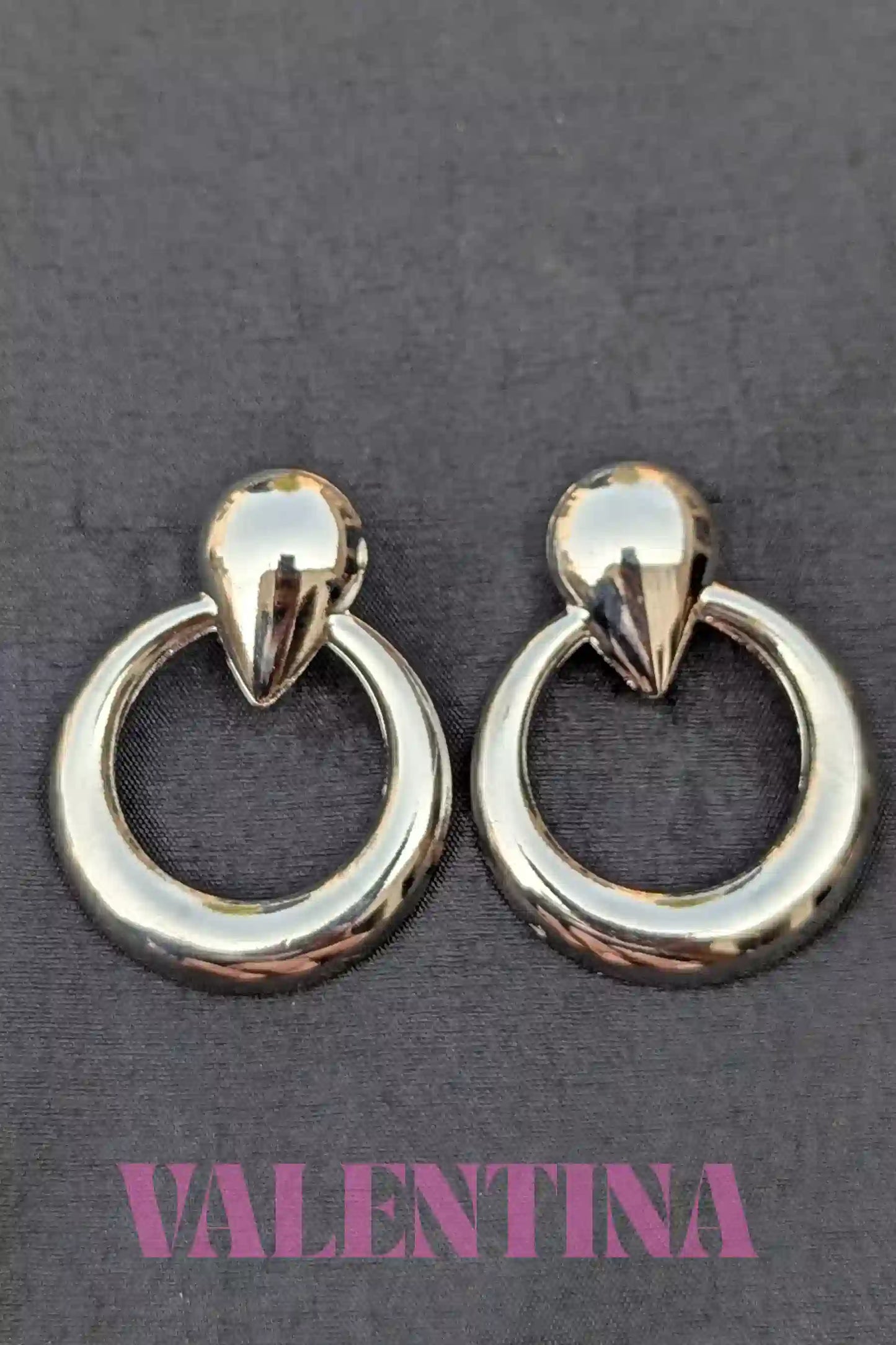 Pair of silver  hoop earrings on a dark background with 'Valentina' branding.