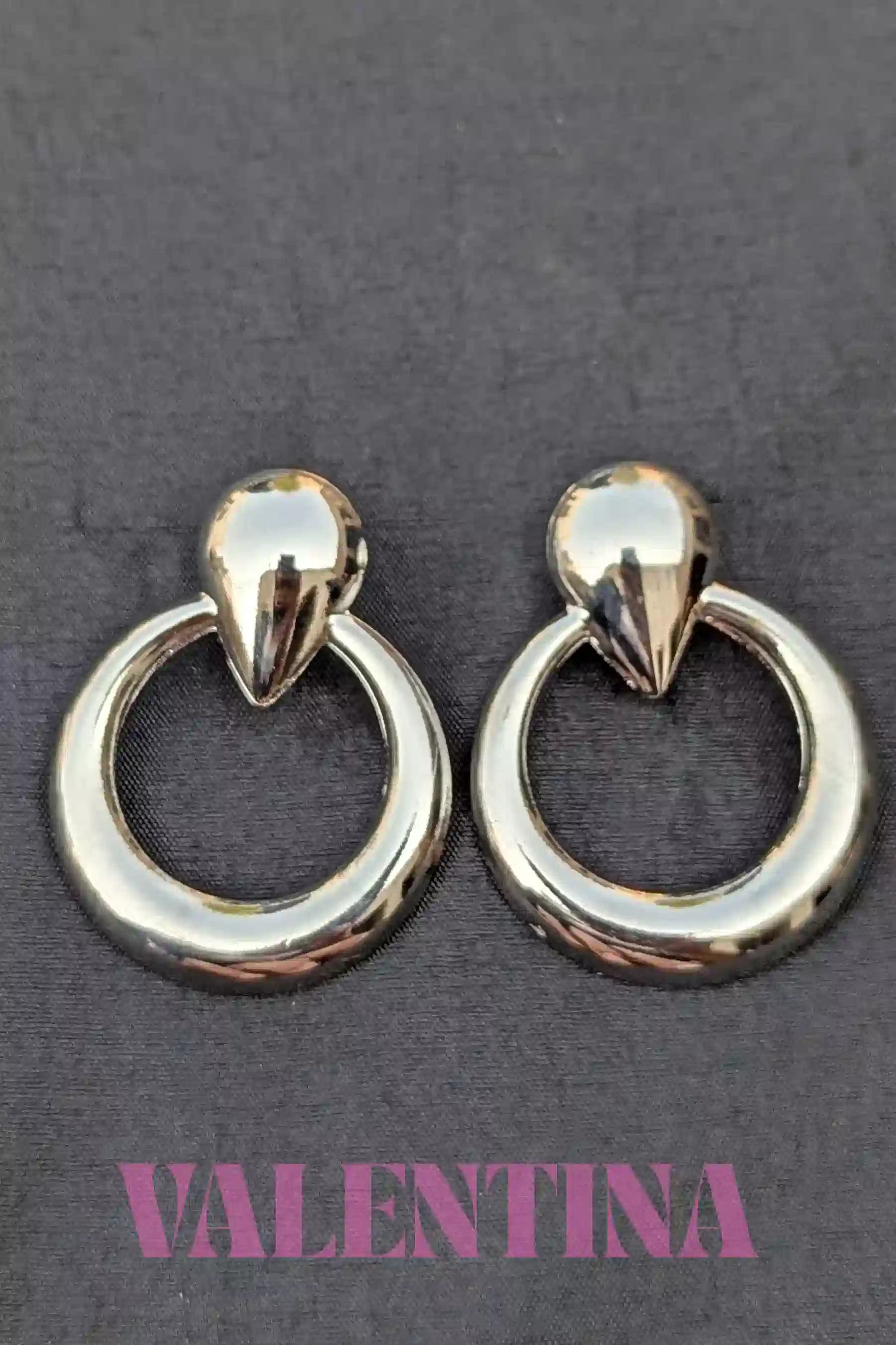 Pair of silver  hoop earrings on a dark background with 'Valentina' branding.