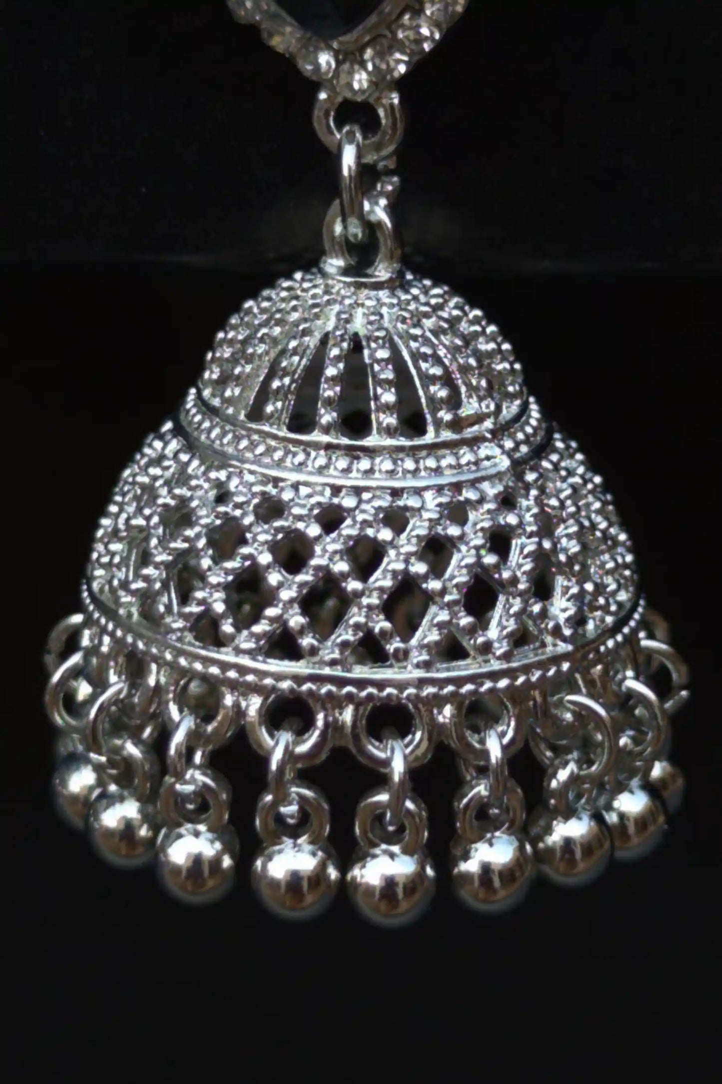 Silver jhumka pendant on a black background