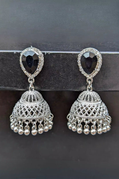 Pair of silver earrings with black gemstones on a dark background