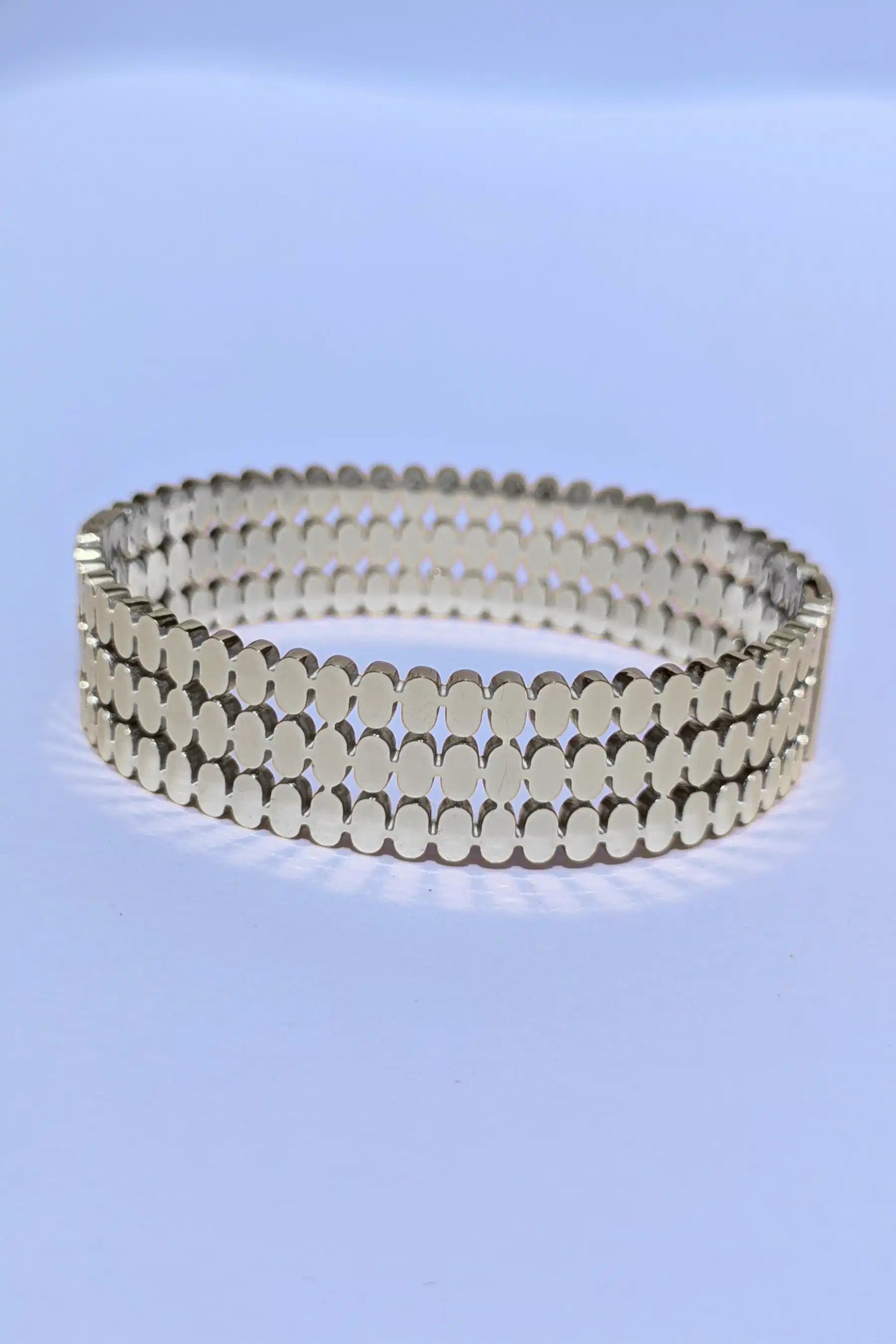 Silver bracelet on a light blue background