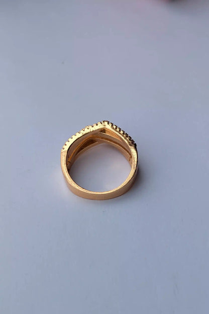 Gold ring with textured band on a light gray background